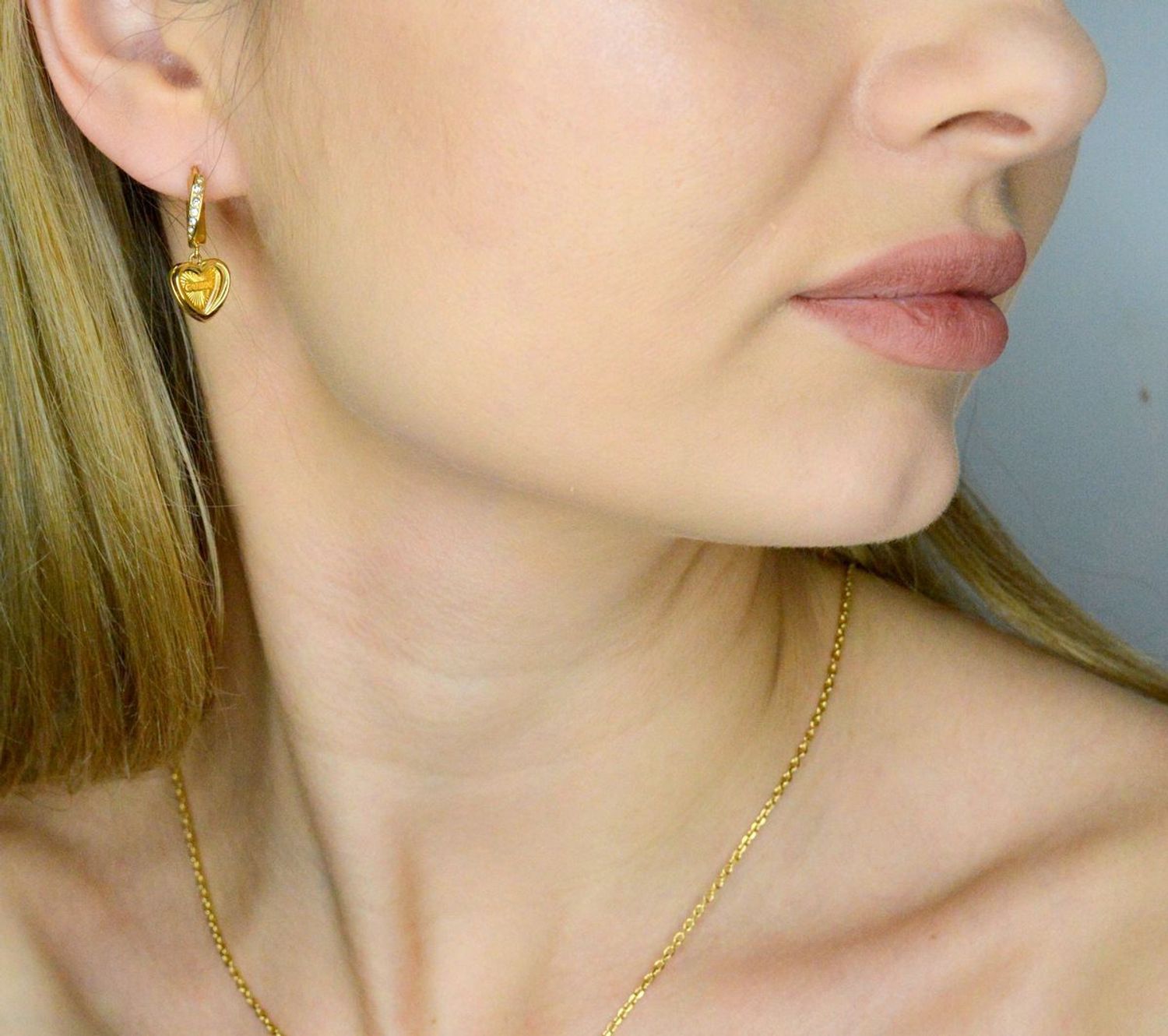 Kolczyki GUESS wiszące serca JUBE04615JWYGTU to błyszczące dodatki, które podkreślają piękno każdej użytkowniczki. Wykonane ze stali szlachetnej, ozdobione cyrkonią. 1.webp