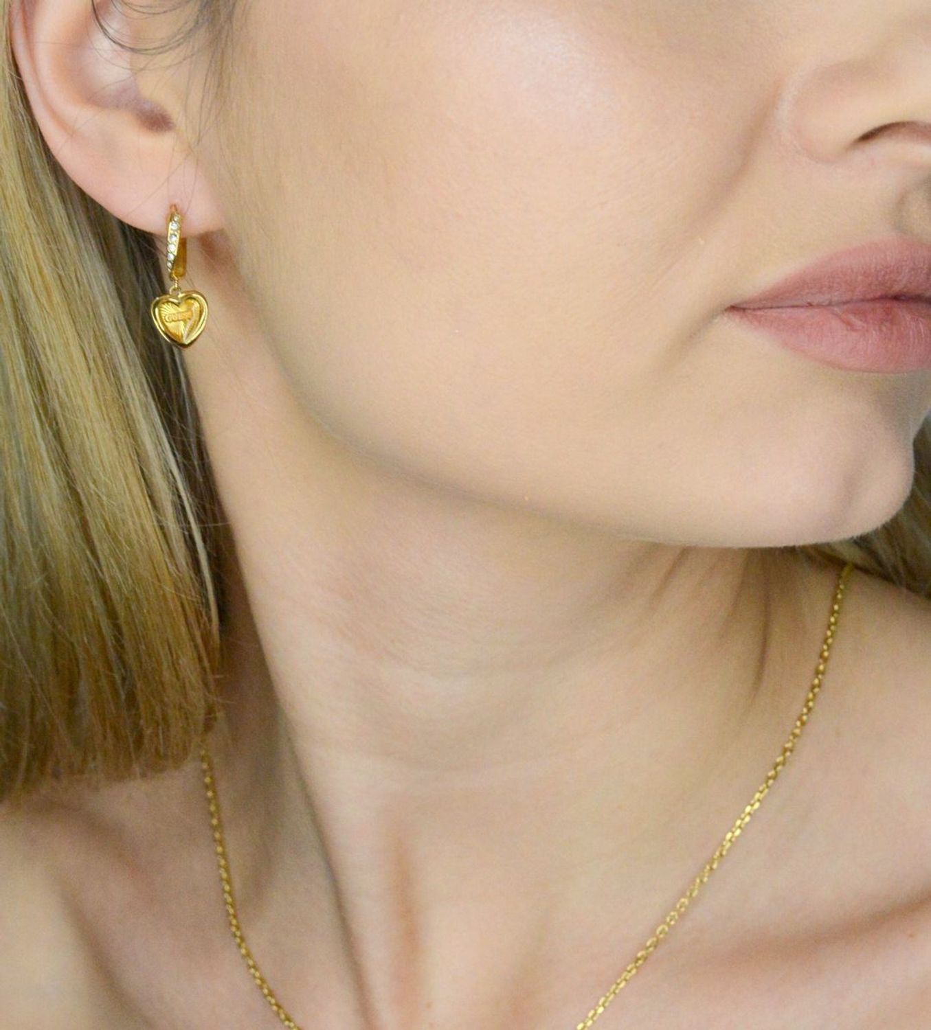 Kolczyki GUESS wiszące serca JUBE04615JWYGTU to błyszczące dodatki, które podkreślają piękno każdej użytkowniczki. Wykonane ze stali szlachetnej, ozdobione cyrkonią. 1.webp