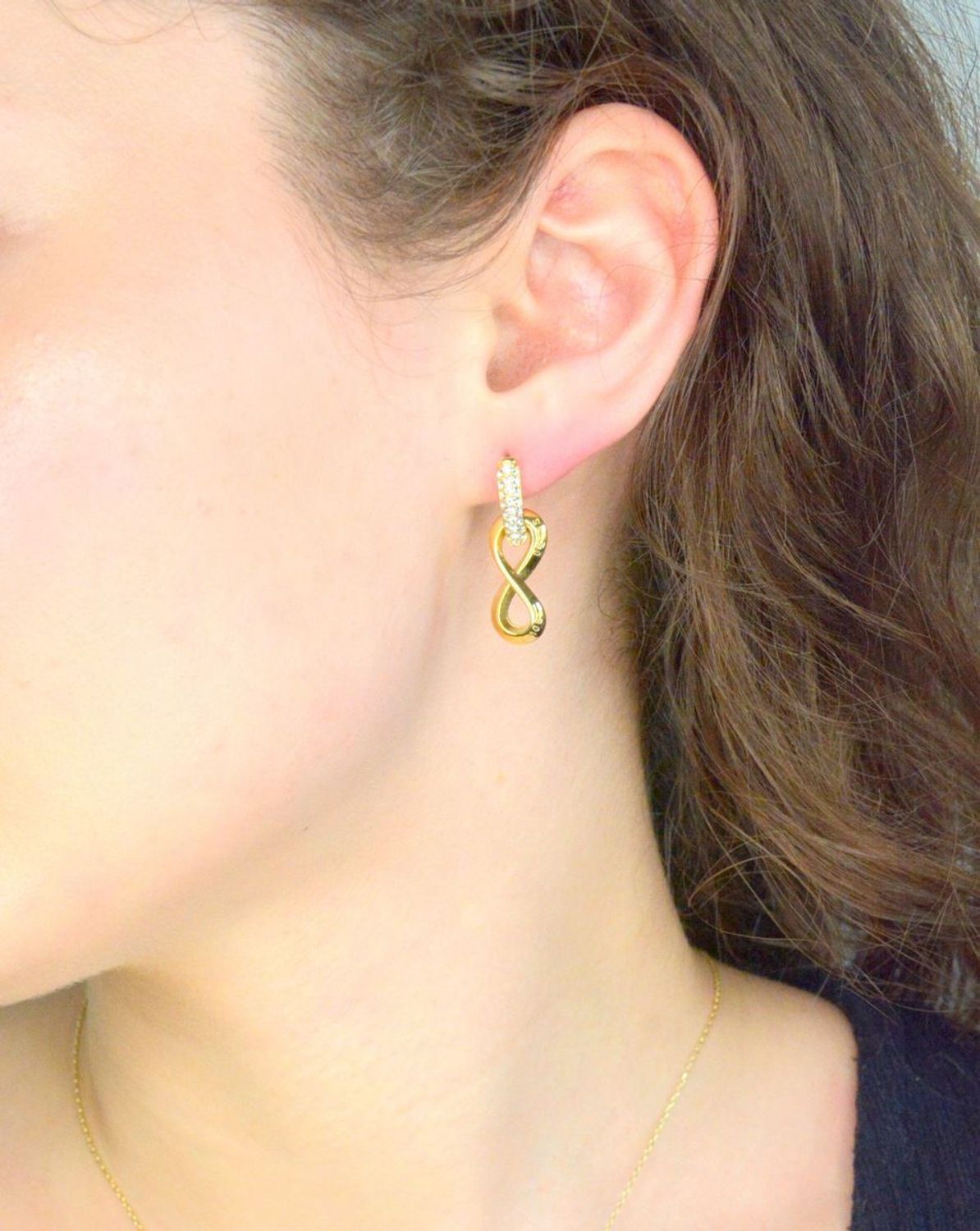 Kolczyki GUESS nieskończoność JUBE05051JWYGT-U to błyszczące dodatki, które podkreślają piękno każdej użytkowniczki. Wykonane ze stali szlachetnej, ozdobione cyrkonią. Kolczyki w formie wiszących znaków nieskończoności1.jpg