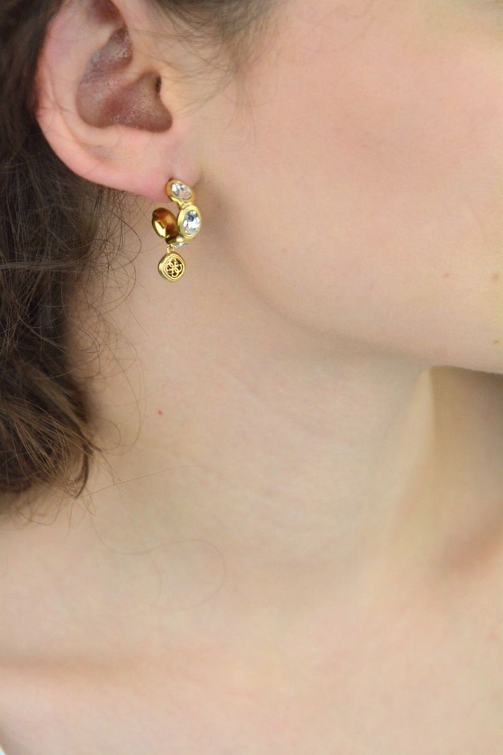 Kolczyki Guess JUBE05571JWYGTU – stalowe kółka pozłacane, z dużymi cyrkoniami i zawieszką z logo GUESS. Długość 2,5 cm, zapięcie na sztyft. Stylowa i nowoczesna biżuteria.1a.jpg