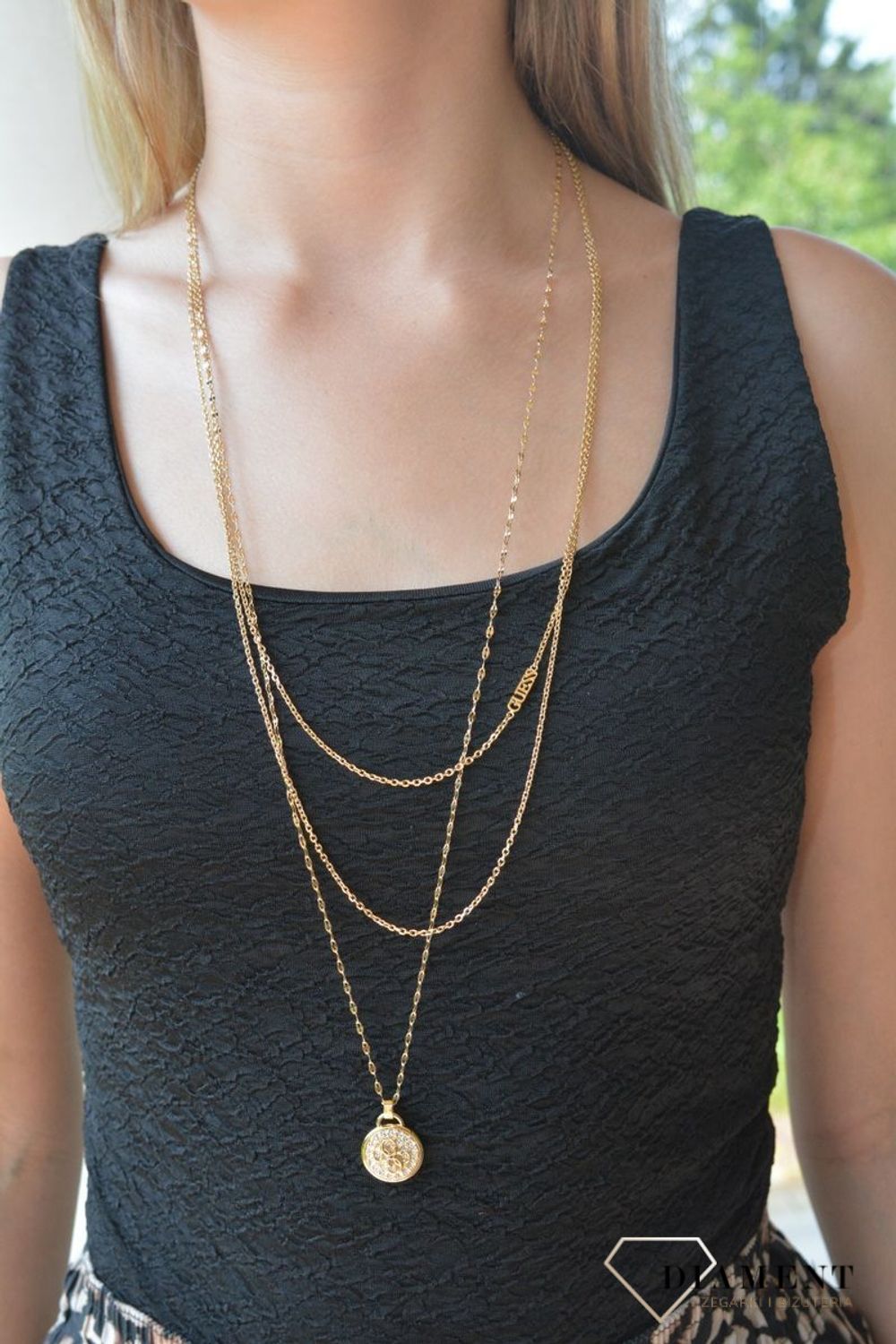 Naszyjnik damski Guess Dreaming JUBN03127JWYGT-U . Stalowy, ozdobny naszyjnik z zawieszką okrągłą  wysadzoną cyrkoniami i ozdobioną logo marki Guess. Wyjątkowa ozdoba, która świetnie się sprawdzi jako dodatek do letnich stylizacji. Naszyjnik 68.jpg