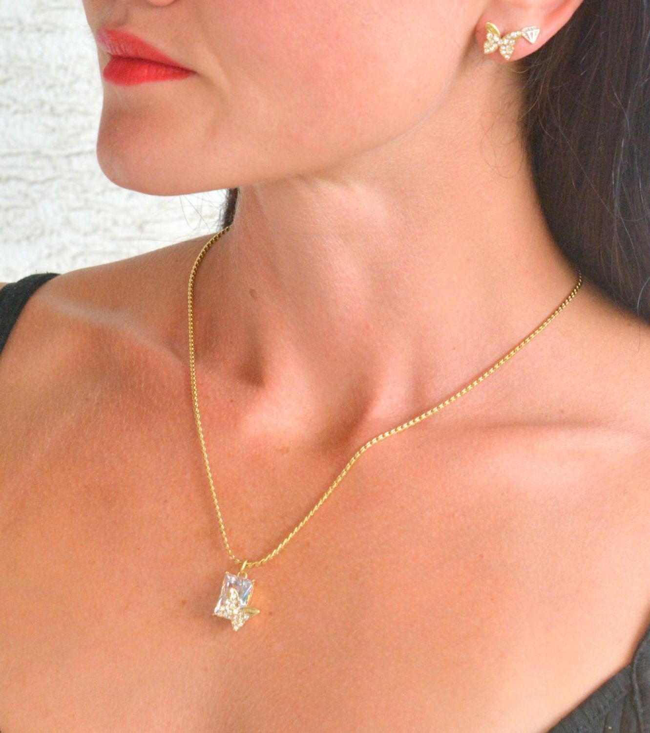 Naszyjnik GUESS pozłacany Chrysalis z prostokątnym kryształkiem i motylem JUBN04097JWYGT-U.png