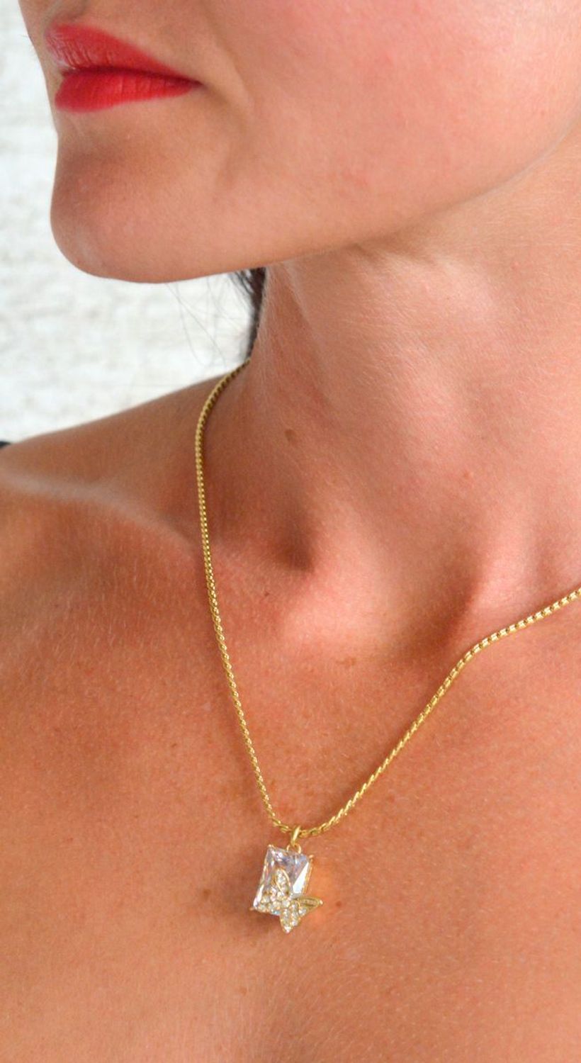 Naszyjnik GUESS pozłacany Chrysalis z prostokątnym kryształkiem i motylem JUBN04097JWYGT-U.png