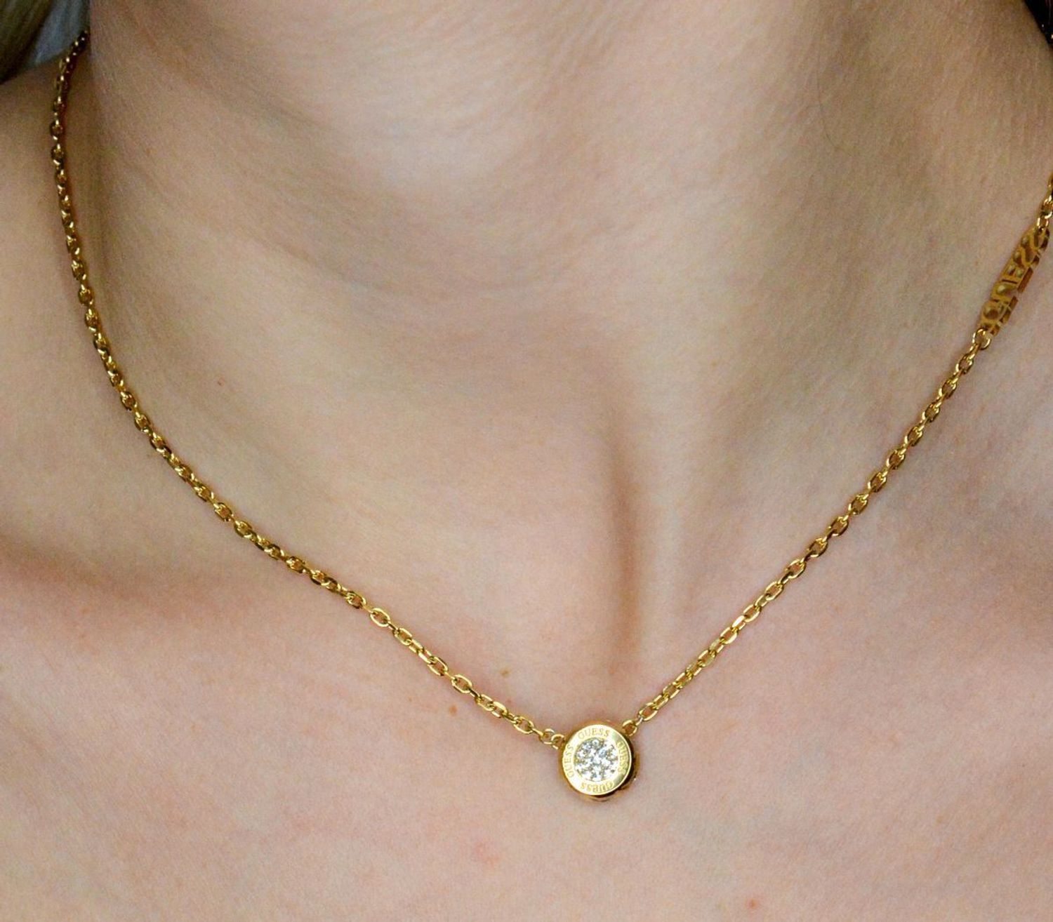 Naszyjnik GUESS JUBN04593JWYGTU Stalowy, naszyjnik składający się z łańcuszka z zawieszką ozdobioną w cyrkonie z logo Guess. Wyjątkowa ozdoba, która świetnie się sprawdzi jako dodatek do eleganckich stylizacji..webp