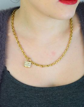 Pozłacany naszyjnik GUESS JUBN05415JWYGTU z zawieszką w kształcie kłódki i zdobieniem z kamieni. Wykonany ze stali szlachetnej, łączy elegancję i trwałość. Idealny na co dzień i wyjątkowe okazje (1).JPG