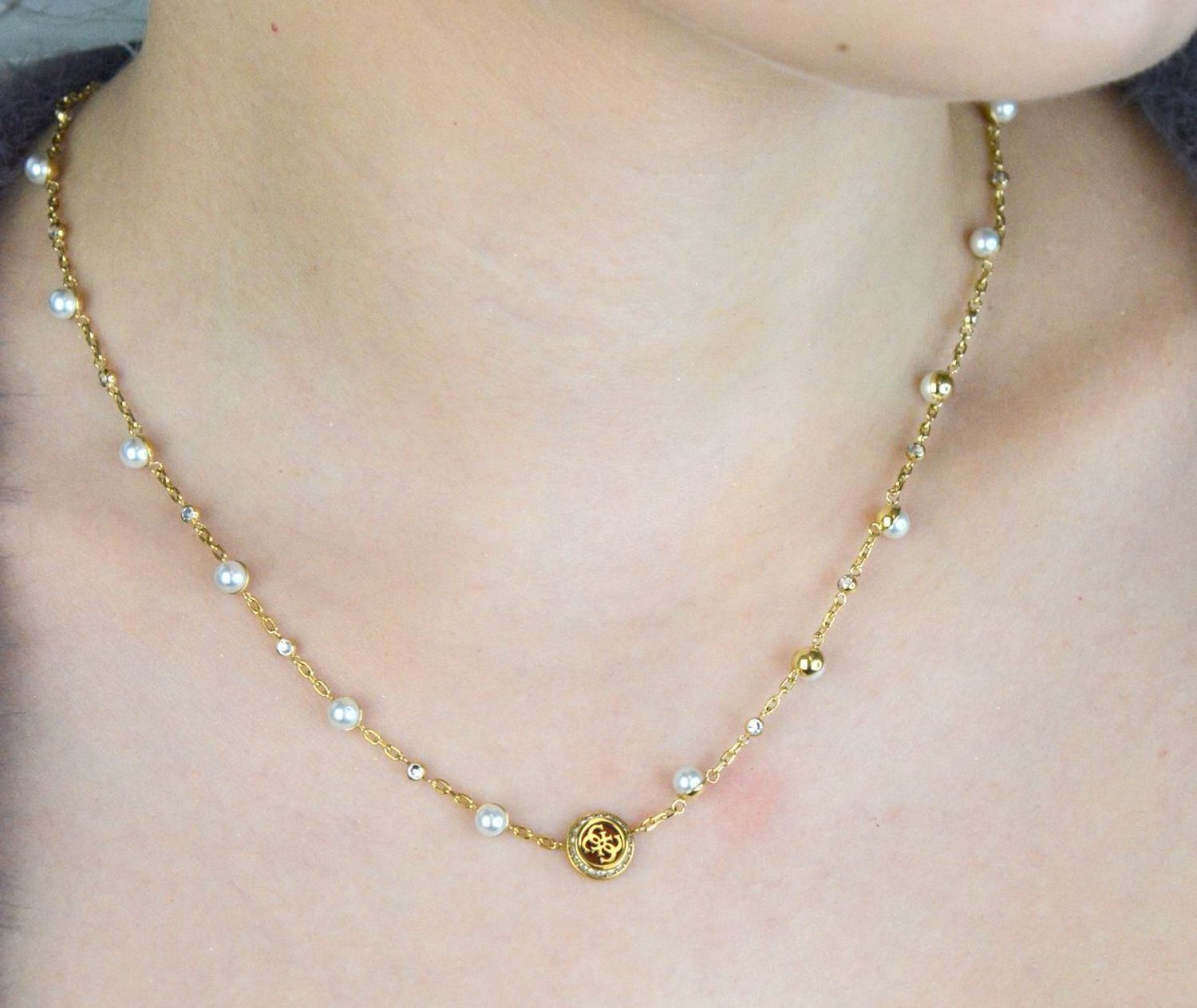 Naszyjnik GUESS Tiny Pearly JUBN05515JWYGTU – elegancki złoty naszyjnik ze stali szlachetnej z zawieszką z logo GUESS, perłowymi koralikami i kryształkami. Stylowy, kobiecy dodatek idealny na 1.jpg