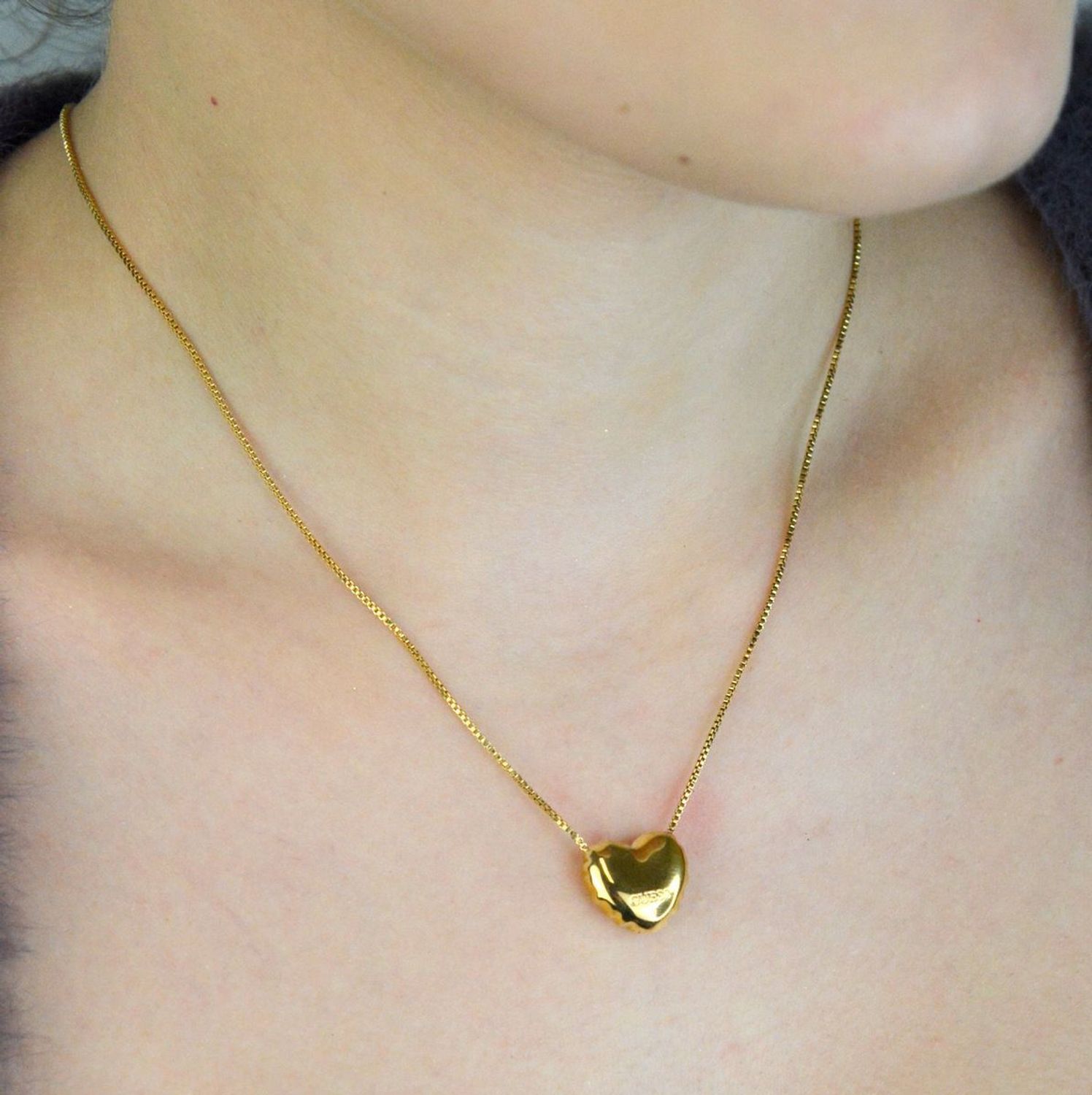 Pozłacany naszyjnik GUESS JUBN05541JWYGTU z zawieszką w kształcie serca i grawerowanym logo marki. Delikatny i elegancki dodatek, idealny na prezent dla kobiety ceniącej styl i ponadczasową1.jpg