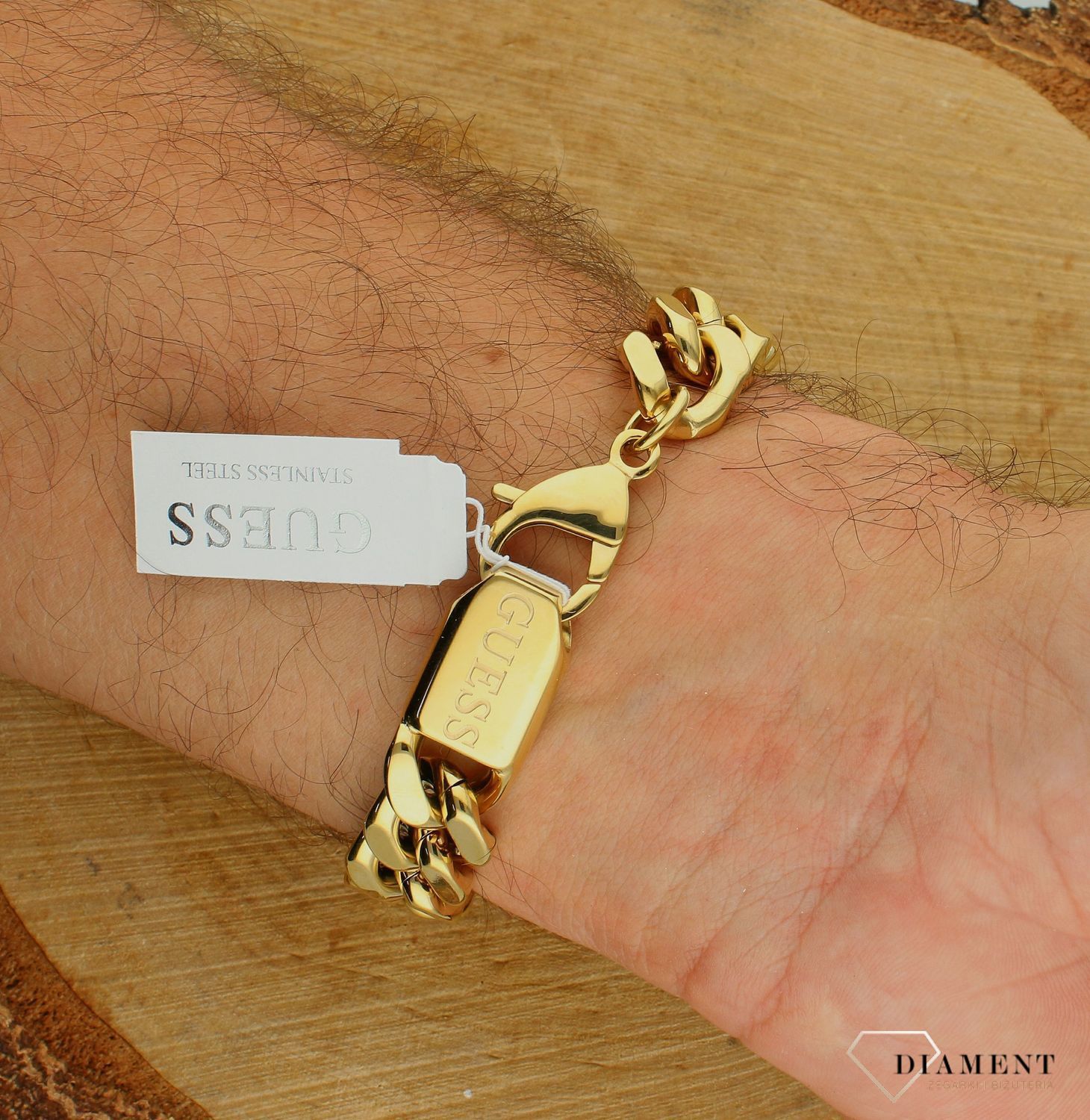 Bransoletka męska GUESS stalowa w złotym kolorze z krzyżem na czarnej blaszce JUMB04022JWYGBKS.jpg