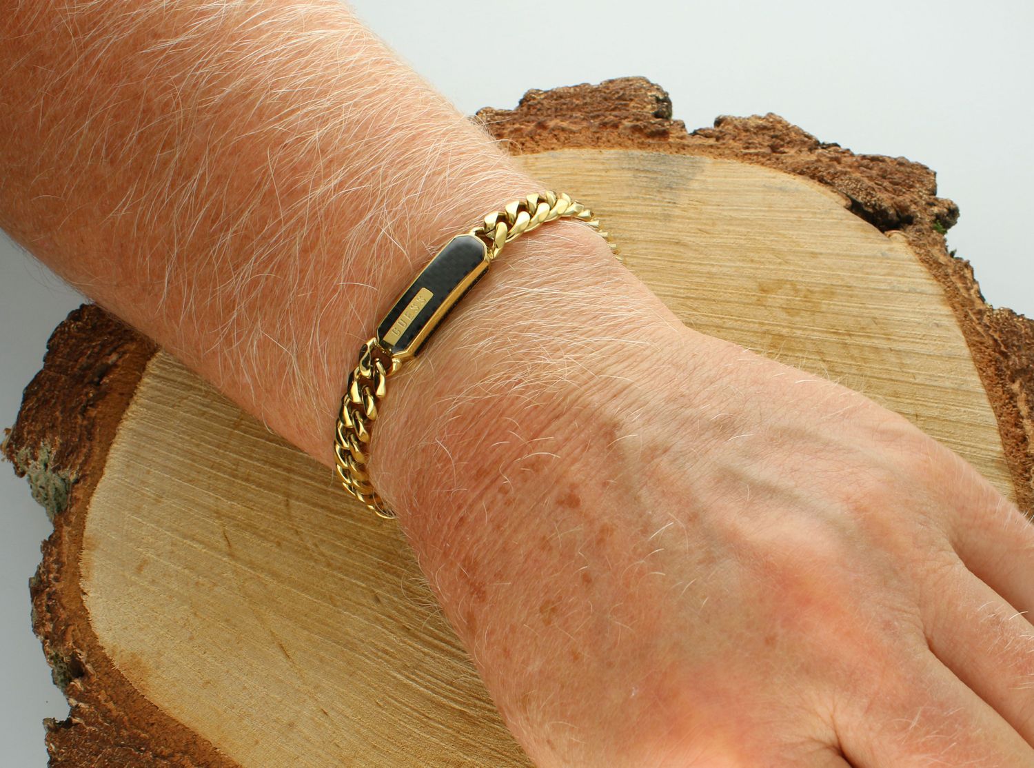 Bransoletka GUESS pancerka JUMB04039JWYGBKS Bransoletka męska Guess w złotym kolorze z logo Guess na czarnej blaszce. Bransoletka Guess w złotym kolorze na łańcuszku o splocie pancerka. 1.jpg