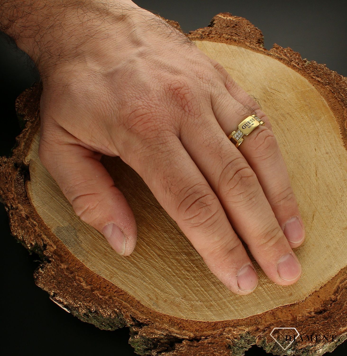 Pierścionek męski GUESS JUMR01344JWYG. Stalowy pierścionek męski pozłacany w formie obrączki. Pierścionek został ozdobiony w modny sposób czytelnym napisem GUESS . Pierścionek został wykonany z najwyższej jakości stali w kol (3).jpg