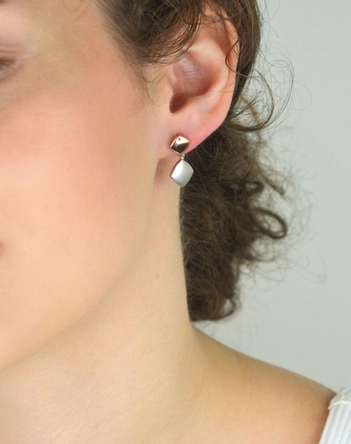 Srebrne kolczyki damskie próba 925, wiszące kwadraciki jeden pozłacany różowym złotem, drugi srebrny satynowy. Długość 2,0 cm, szerokość 1,0 cm, zapięcie na sztyft.1.jpg