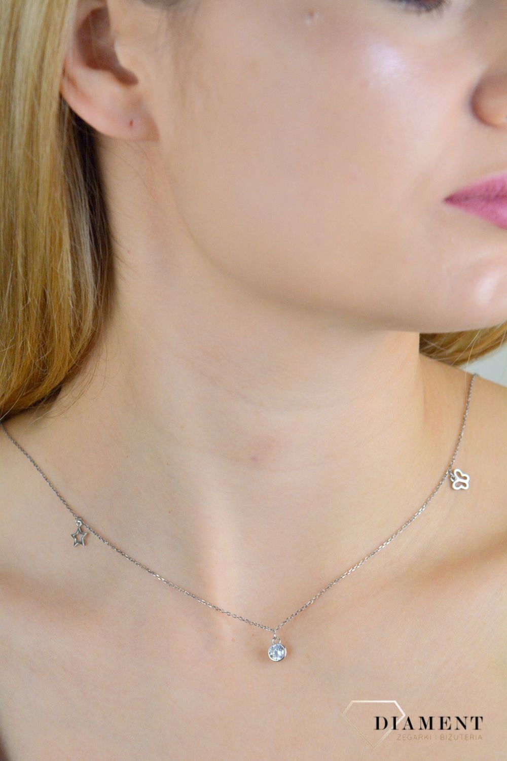 Naszyjnik srebrny damski celebrytka z wiszącymi elementami NVI198040. Naszyjnik wykonany z najwyższej próby srebra z ozdobnym splotem łańcuszka z wiszącymi elementami tj. motylek, gwiazdka, koniczynka oraz okrągła cyrkonia. .jpg