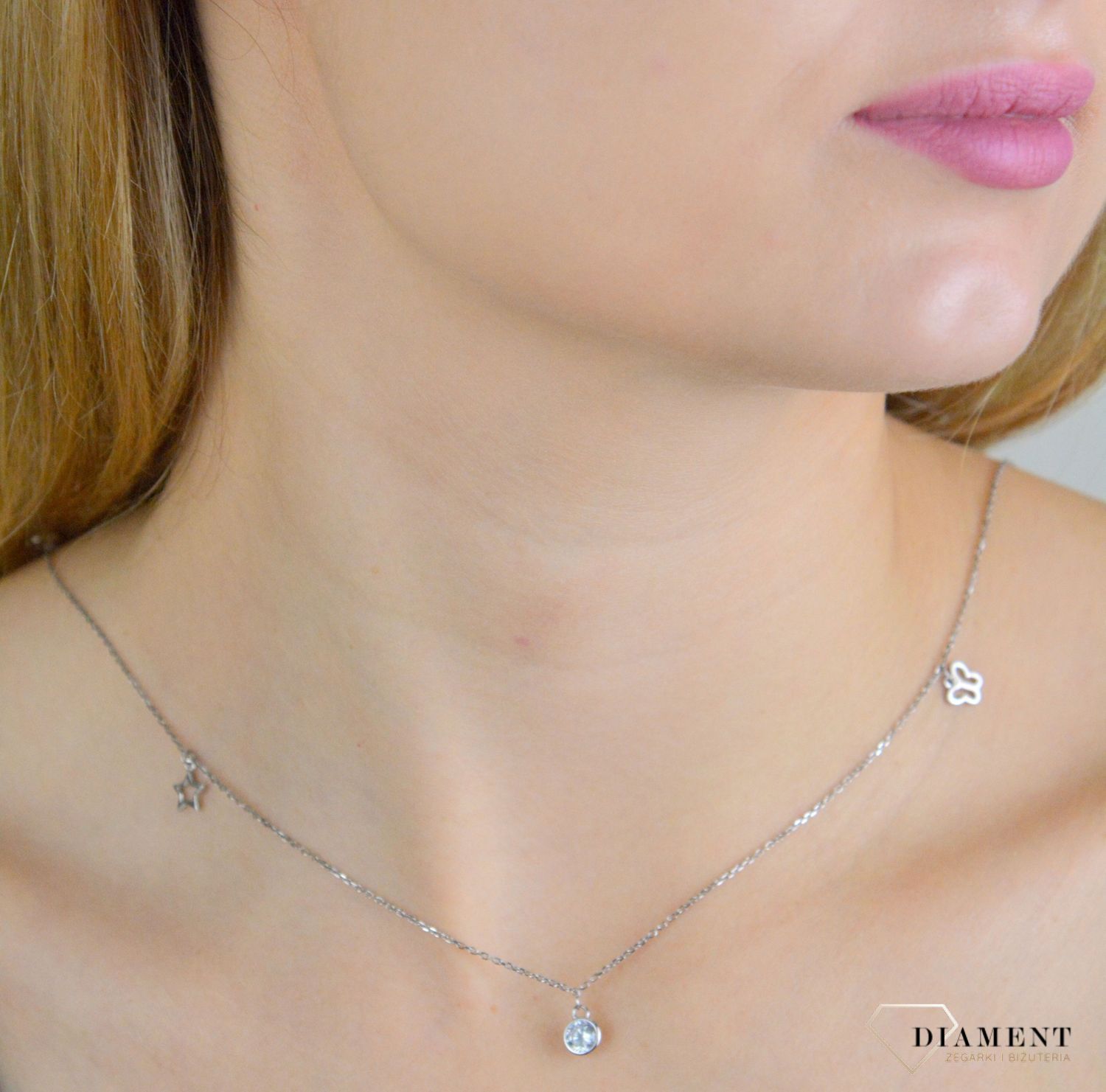 Naszyjnik srebrny damski celebrytka z wiszącymi elementami NVI198040. Naszyjnik wykonany z najwyższej próby srebra z ozdobnym splotem łańcuszka z wiszącymi elementami tj. motylek, gwiazdka, koniczynka oraz okrągła cyrkonia. .jpg