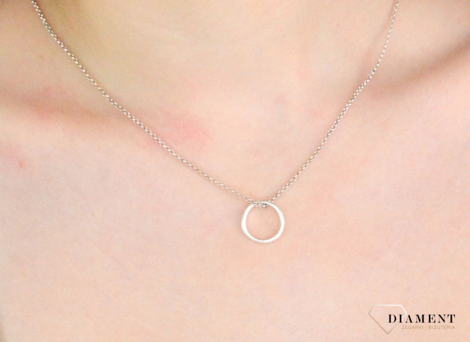 Naszyjnik BY DZIUBEKA kółeczko NASGALA0291 Nowoczesny naszyjnik wykonany z mosiądzu w kolorze srebra, zdobiony otwartym kółeczkiem, stanowi doskonały prezent na każdą okazję. Minimalizm w najpiękniejszym wydaniu. 1.jpg