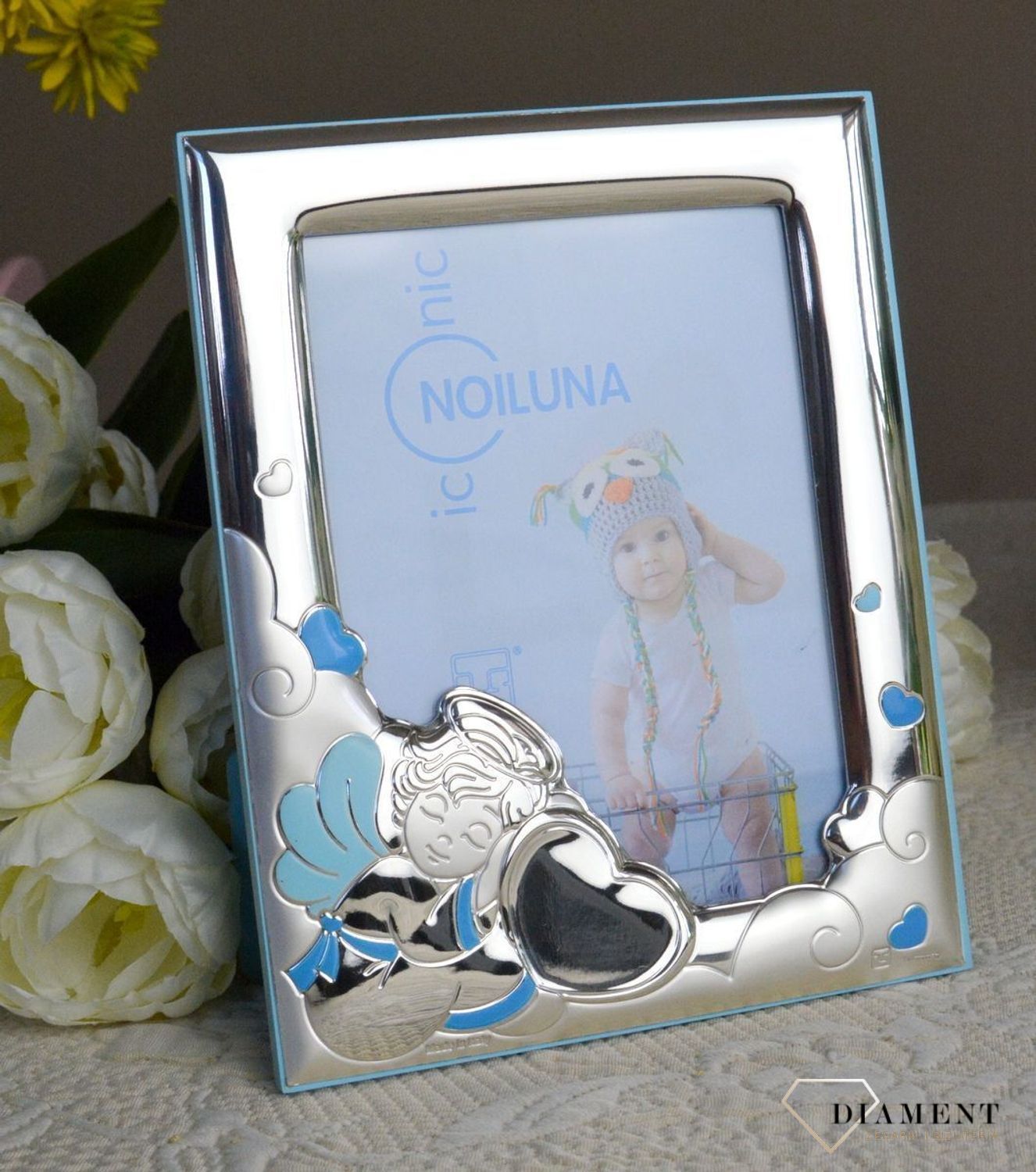 Wyjątkowa ramka na zdjęcie z aniołkiem w kolorze niebieskim. Produkt renomowanej włoskiej firmy znanej z wysokiej jakości wykonania i dbałości o detal. Wykonana jest z wysokiej jakości stali posrebrzanej zabezpieczonej lak.jpg