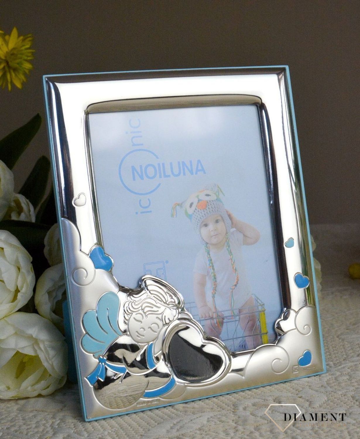 Wyjątkowa ramka na zdjęcie z aniołkiem w kolorze niebieskim. Produkt renomowanej włoskiej firmy znanej z wysokiej jakości wykonania i dbałości o detal. Wykonana jest z wysokiej jakości stali posrebrzanej zabezpieczonej lak.jpg