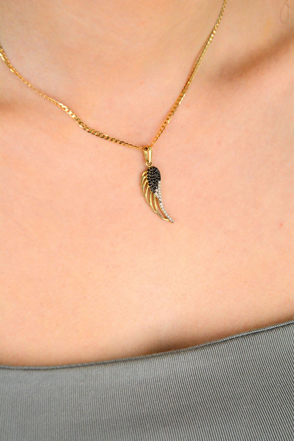 Złota zawieszka skrzydło z czarną i białą cyrkonią próba 333, OPZ000000-381. Symbol wolności, elegancji i blasku! 🕊️ Ta złota zawieszka w kształcie skrzydła jest ozdobiona kontrastującymi1.jpg