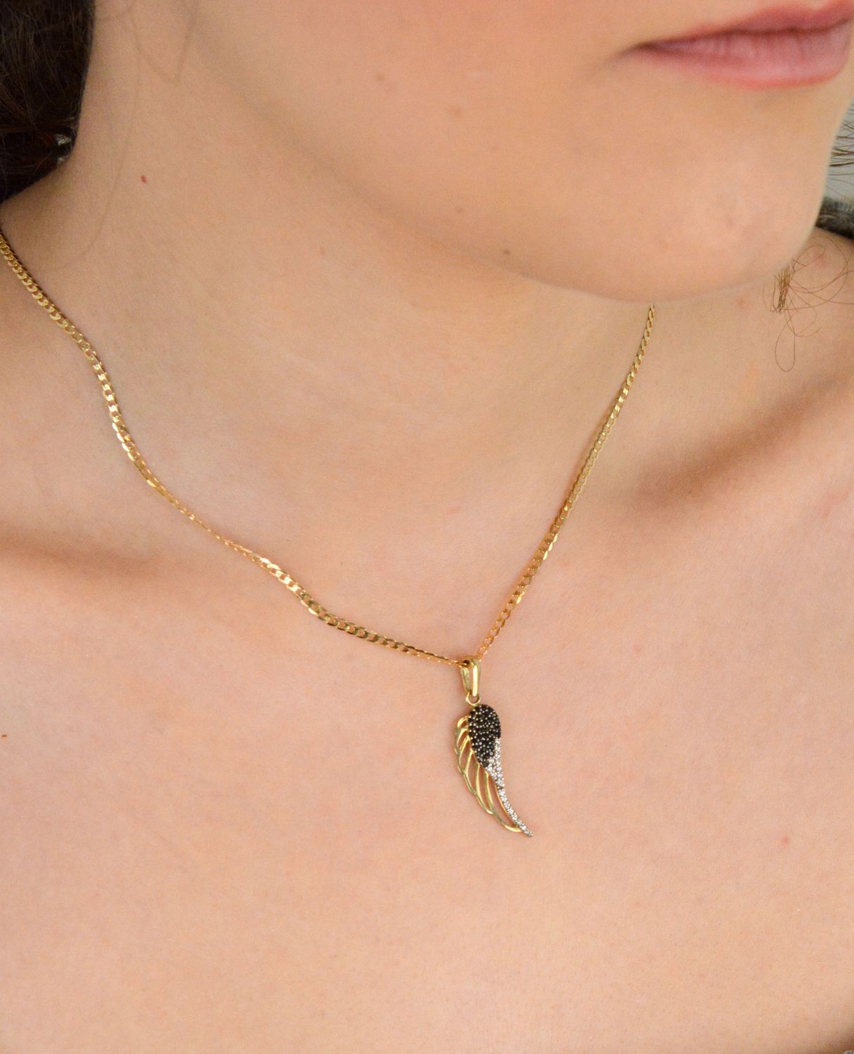 Złota zawieszka skrzydło z czarną i białą cyrkonią próba 333, OPZ000000-381. Symbol wolności, elegancji i blasku! 🕊️ Ta złota zawieszka w kształcie skrzydła jest ozdobiona kontrastującymi1.jpg