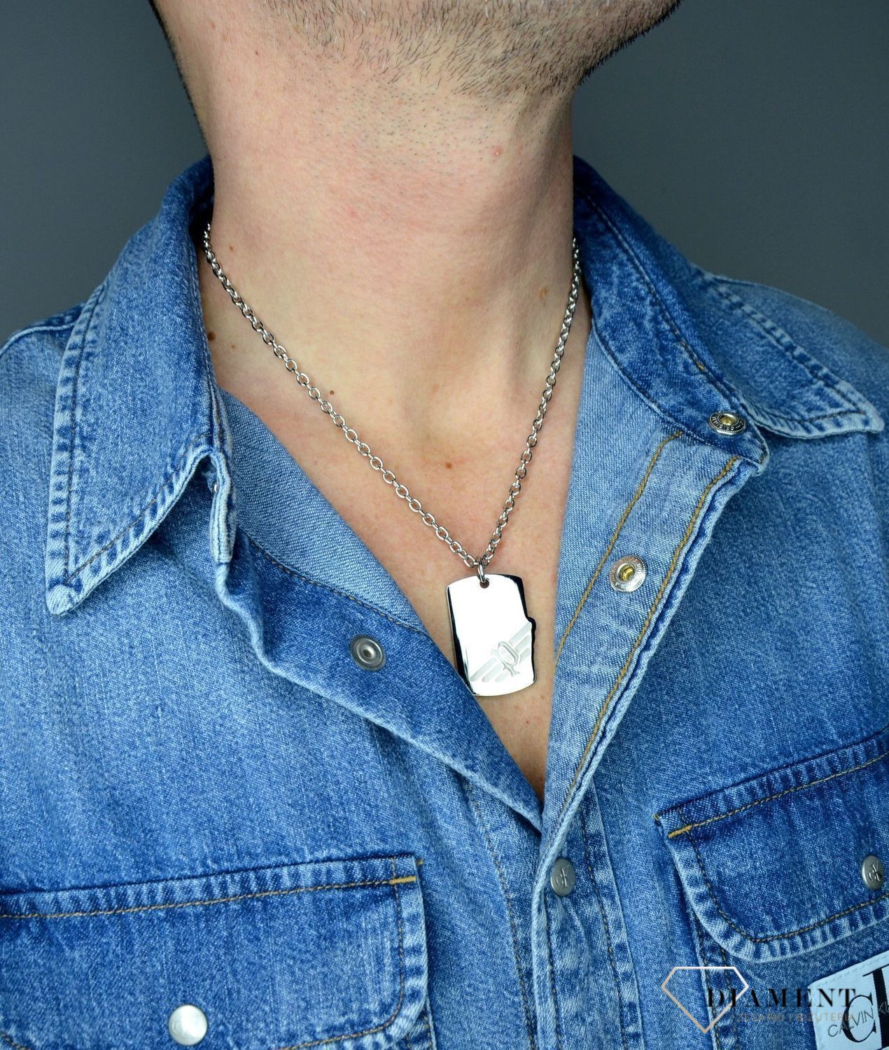 Naszyjnik POLICE PJ.26284PSS-01. Męski wisiorek typu nieśmiertelnik z firmy POLICE. Surowy charakter oraz żłobienia na powierzchni stalowej zawieszki, świetnie prezentuje się z łańcuszkiem w zestawie o klasycznym splo.jpg