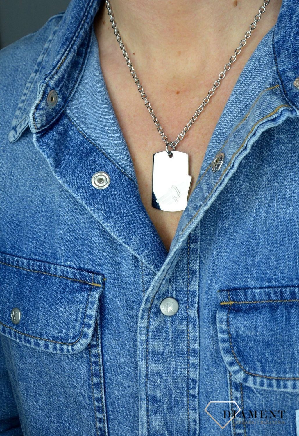 Naszyjnik POLICE PJ.26284PSS-01. Męski wisiorek typu nieśmiertelnik z firmy POLICE. Surowy charakter oraz żłobienia na powierzchni stalowej zawieszki, świetnie prezentuje się z łańcuszkiem w zestawie o klasycznym splo.jpg