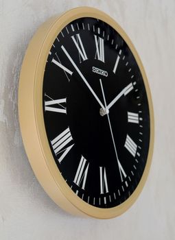 Zegar ścienny złoto czarny Seiko QHA009G- 31 cm. Zegar ścienny złoty z czarną tarczą Seiko. Zegar ścienny do salonu Seiko QHA009G to ozdobny, prosty zegar pasujący do każdego wnętrza. Ciekawa stylizacja zegara w kolorze złotym (4).JPG
