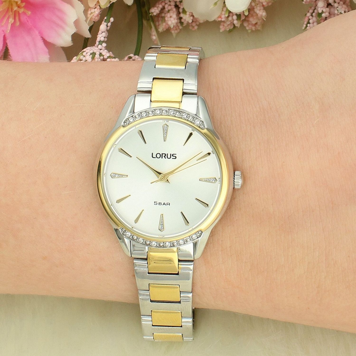 Lorus Classic RG256YX9 to damski zegarek, który łączy klasyczną elegancję z biżuteryjnym wykończeniem. Model wyróżnia się ponadczasową stylistyką, srebrną tarczą oraz subtelnymi cyrkoniami, które dodają mu szyku i deli.jpg