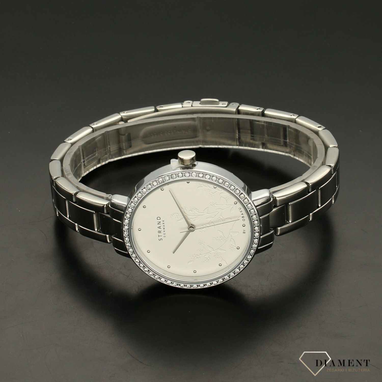 Zegarek damski STRAND Pacifica S712LXCISC. Strand Pacifica to elegancki zegarek damski z oryginalną, białą tarczą ozdobioną kwiatowym motywem. Zegarek damski posiada indeksy ze srebra. Tarcza ozdobiona jest błyszczą8.jpg