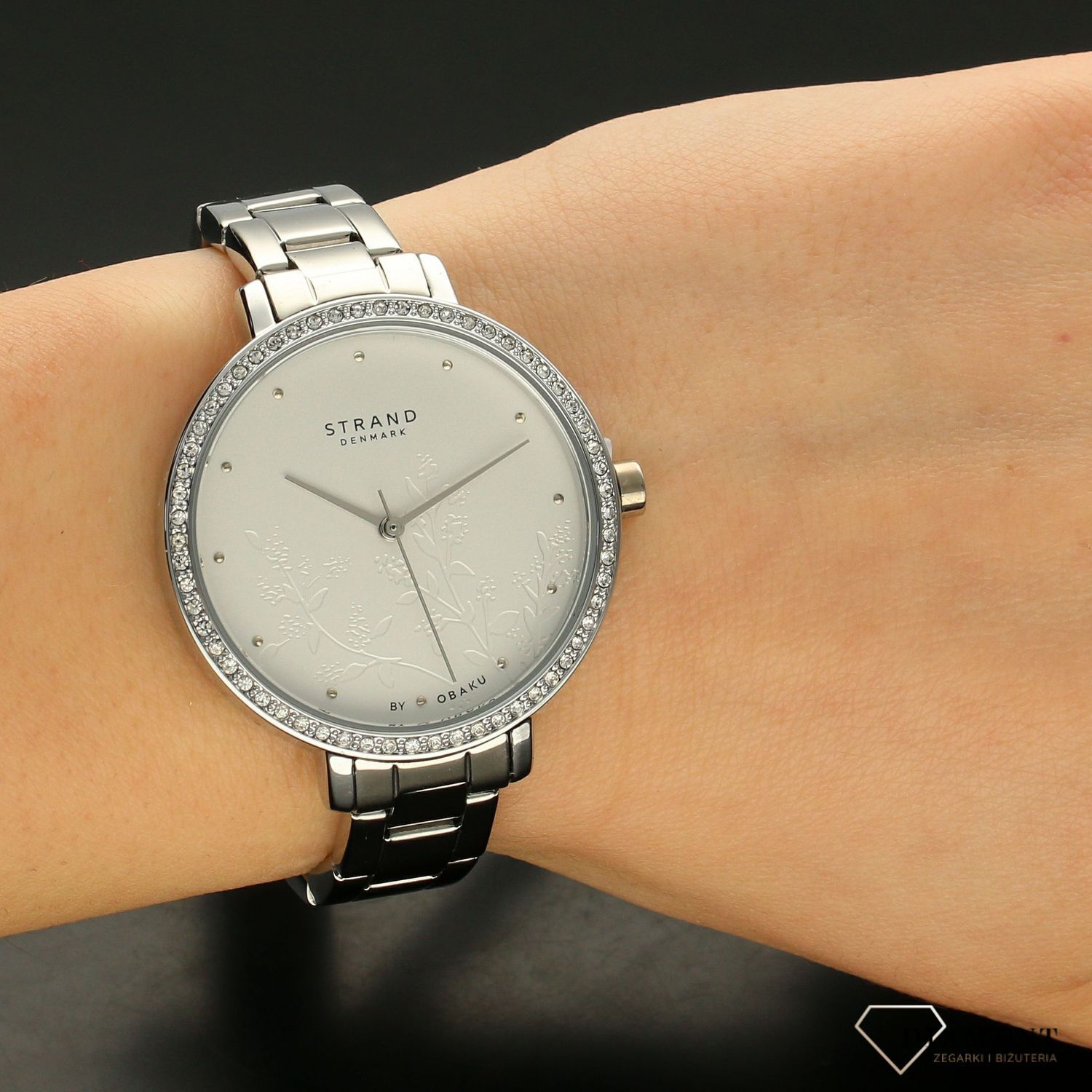 Zegarek damski STRAND Pacifica S712LXCISC. Strand Pacifica to elegancki zegarek damski z oryginalną, białą tarczą ozdobioną kwiatowym motywem. Zegarek damski posiada indeksy ze srebra. Tarcza ozdobiona jest błyszczą8.jpg