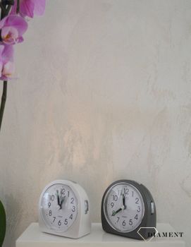 Budzik klasyczny JVD szary SRP213.1 ✅ Budzik czeskiej marki JVD o klasycznym wyglądzie w kolorze szarym. ✅ Tarcza zegarka w kolorze białym z czarnymi cyframi arabskimi (5).JPG