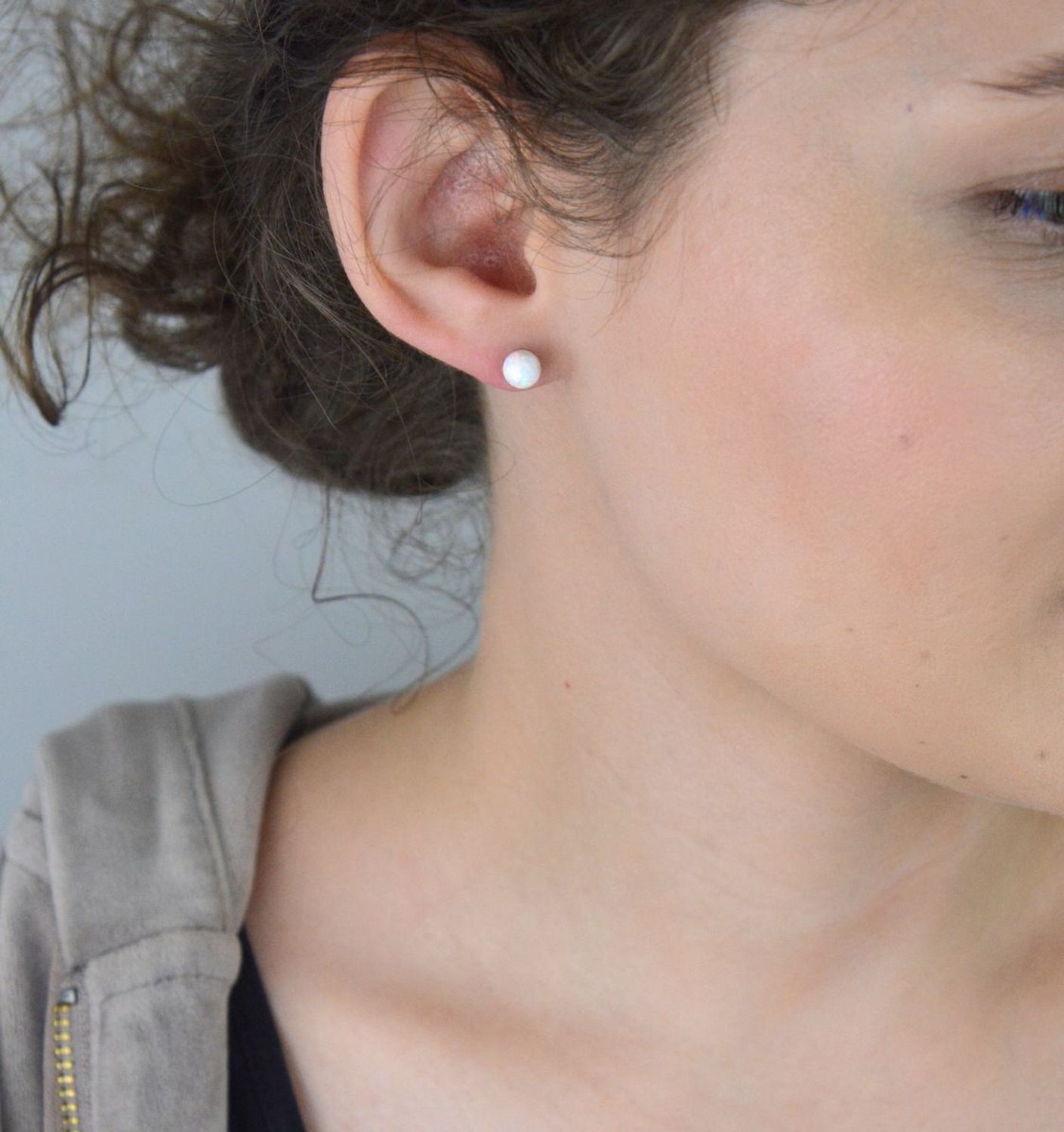 Srebrne kolczyki ozdobione opalem na sztyft. Delikatne kolczyki wykonane z najwyższej jakości srebrna próby 925 wyglądają bardzo elegancko. Kolczyki w minimalistycznym stylu, wpisujące się w obecne trendy modowe..webp