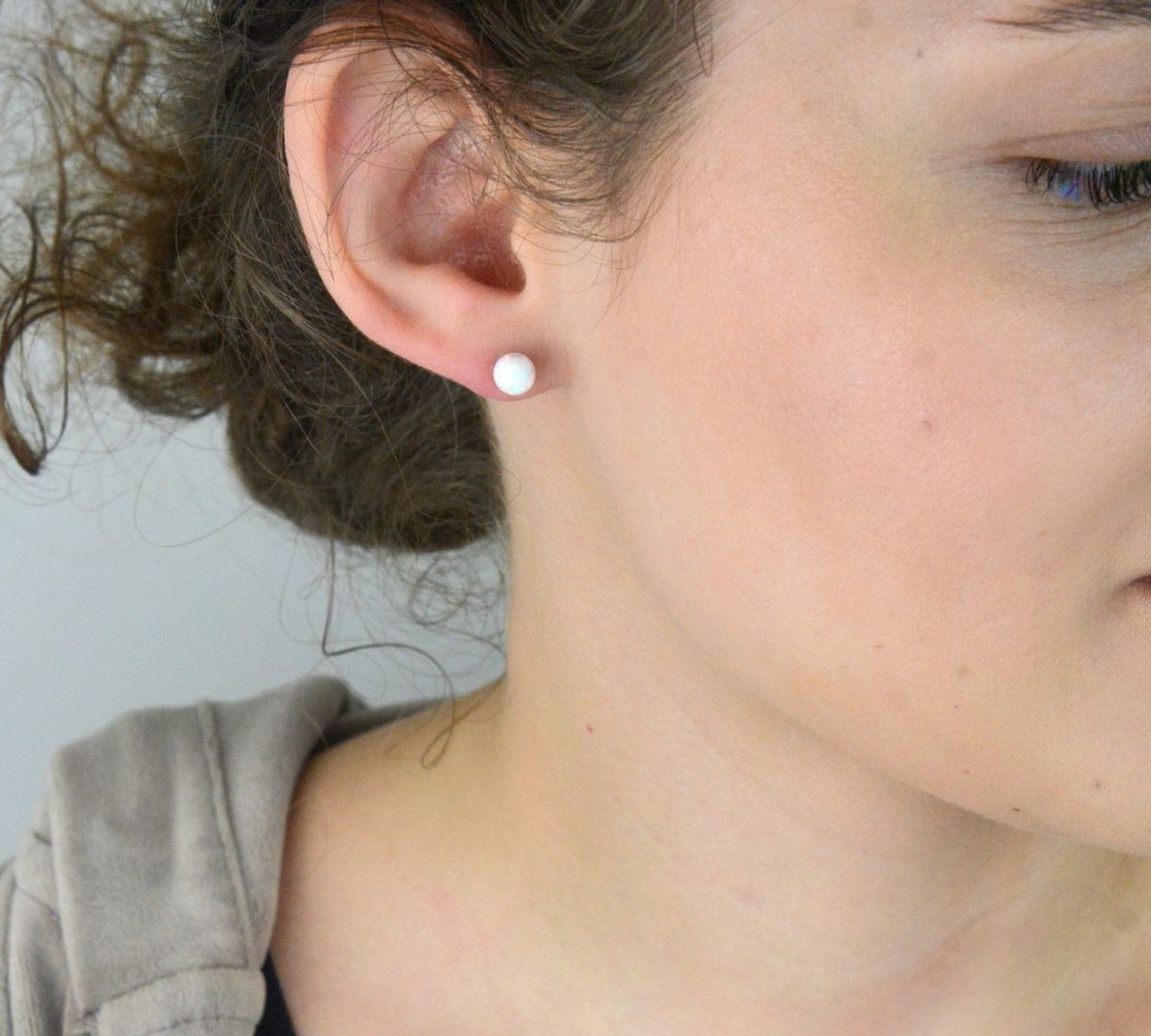 Srebrne kolczyki ozdobione opalem na sztyft. Delikatne kolczyki wykonane z najwyższej jakości srebrna próby 925 wyglądają bardzo elegancko. Kolczyki w minimalistycznym stylu, wpisujące się w obecne trendy modowe..webp