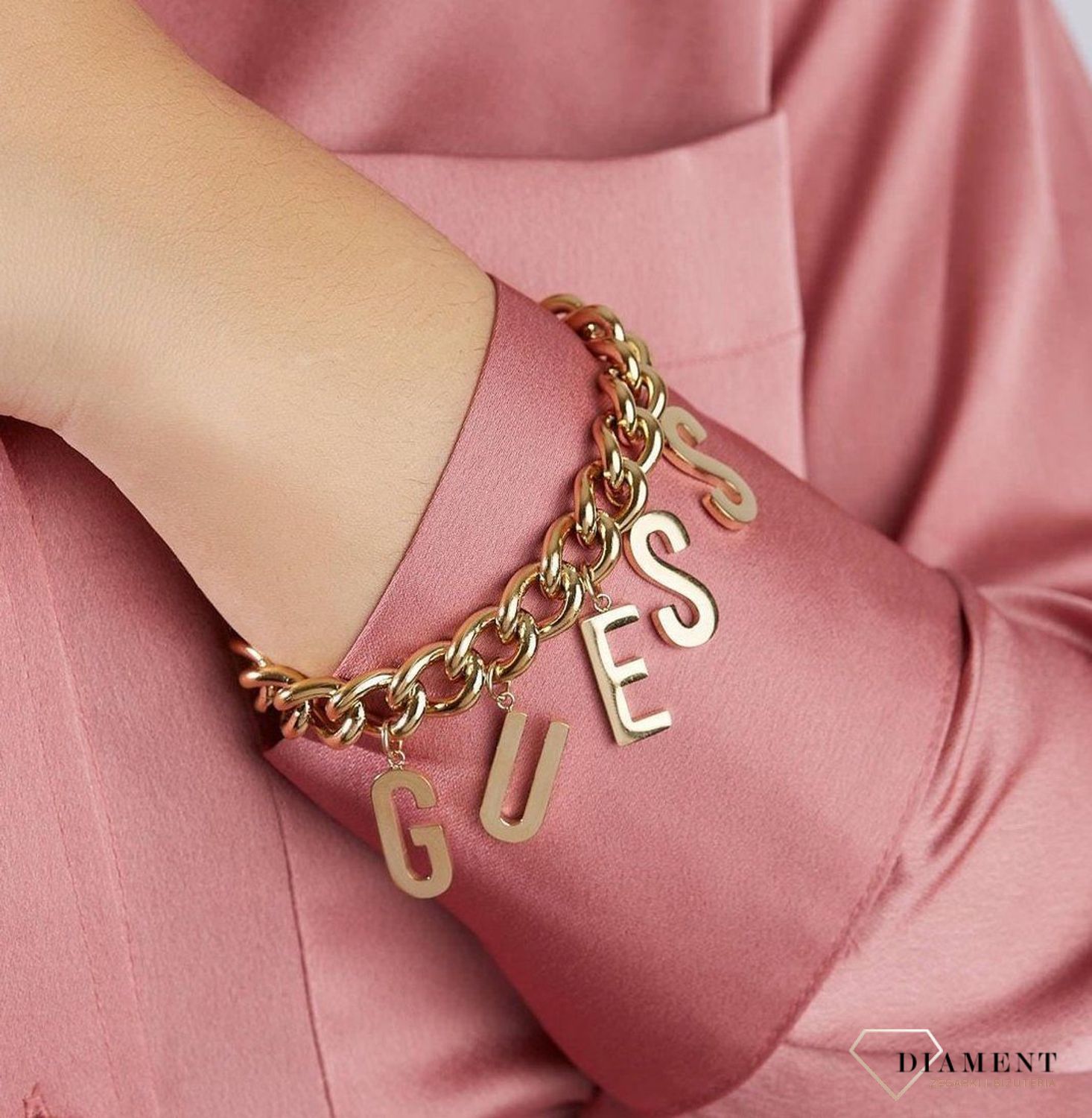 Bransoletka w kolorze złota Guess UBB20006-S.  Bransoletka damska GUESS ze stali z zapięciem w kolorze złota. Bransoletka damska Guess w kolorze złota z  elementami ozdobnym w formie napisu Guess.  (2).jpg