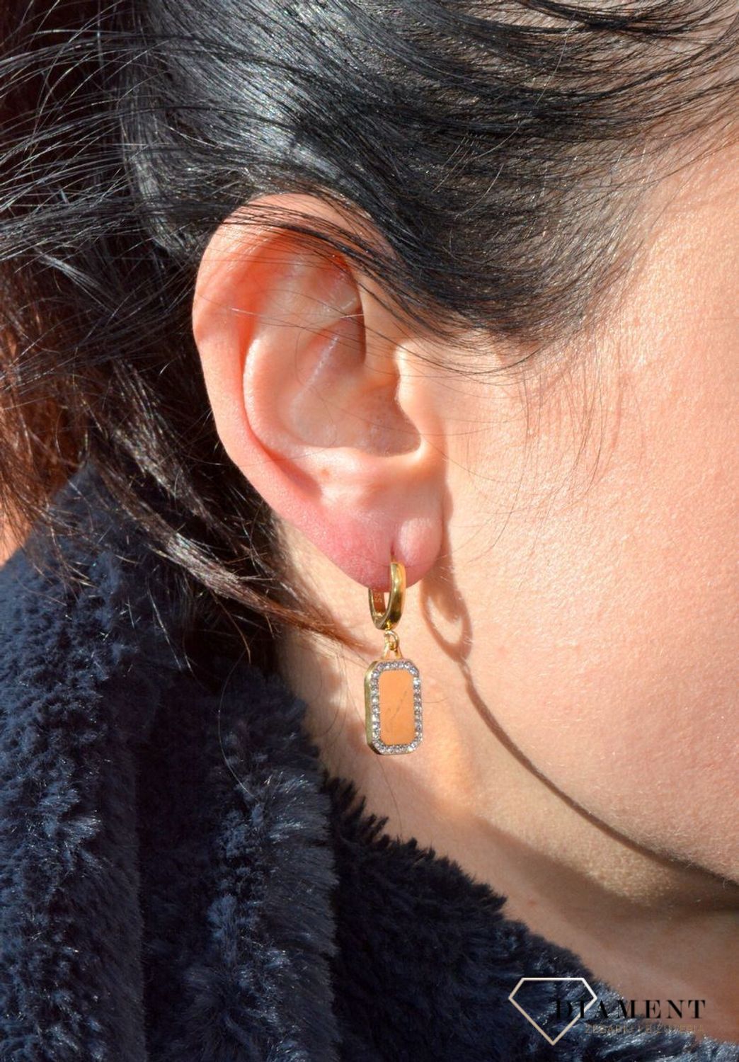 Kolczyki GUESS złote blaszki z cyrkoniami UBE01133JWYGTU. Stalowe kolczyki wiszące z logo marki GUESS w kolorze złota ozdobione cyrkoniami. Kolczyki składają się z.jpg