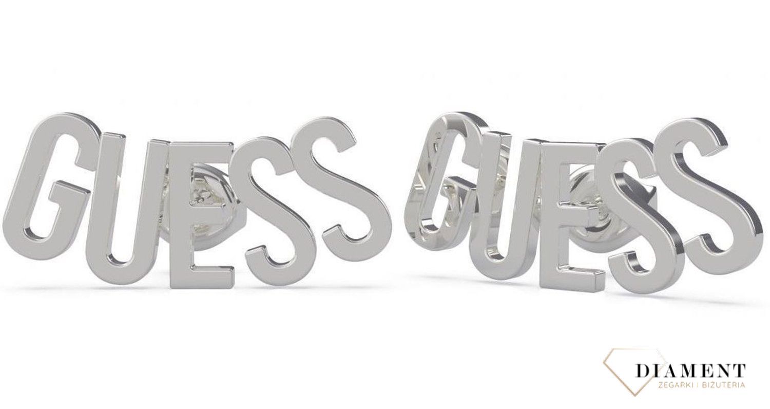 Kolczyki Guess w kolorze srebra UBE20000. Stalowe kolczyki w kolorze srebra wykonane z najwyższej jakości stali. Eleganckie, srebrne kolczyki z ozdobnym elementem w formie napisu Guess.  (2) — kopia.jpg