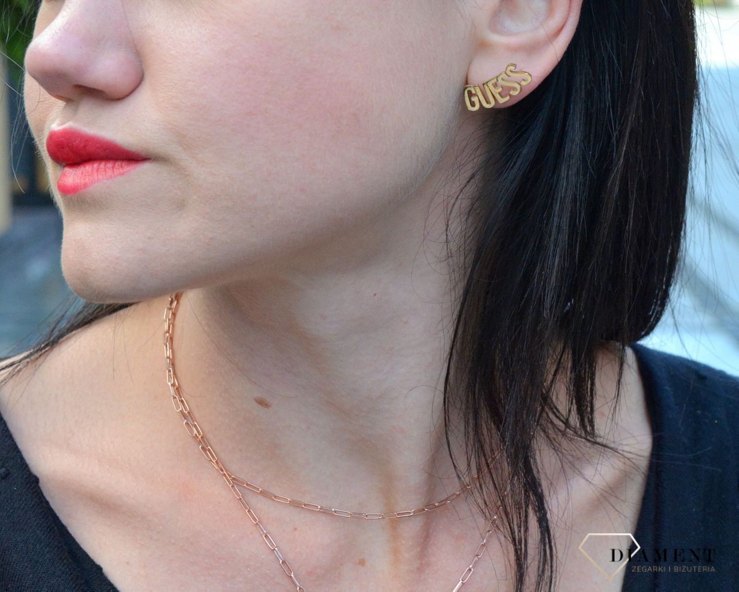 Kolczyki Guess w kolorze złotym UBE20001. Stalowe kolczyki w kolorze złotym wykonane z najwyższej jakości stali. Eleganckie, srebrne kolczyki z ozdobnym elementem w formie napisu Guess.  (2).jpg