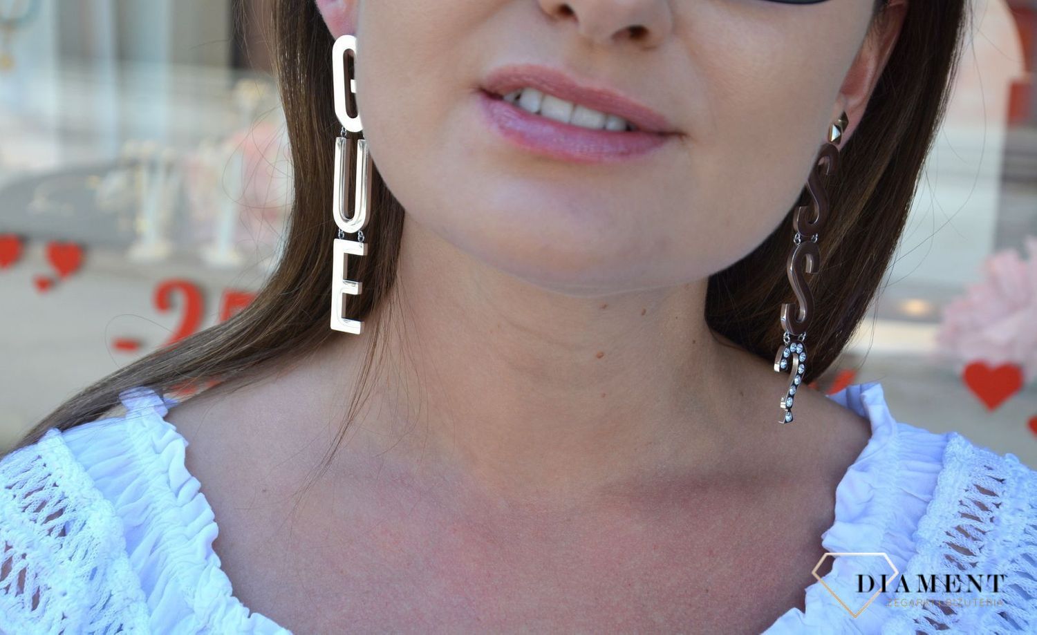 Kolczyki GUESS stalowe duży napis Guess UBE20002. Stalowe kolczyki duży napis Guess. Wiszące kolczyki z wygodnym zapięciem na sztyft. Kolczyki zostały wykonane w modny sposób. Idealnie komponuje się z ponadczasowym b.webp