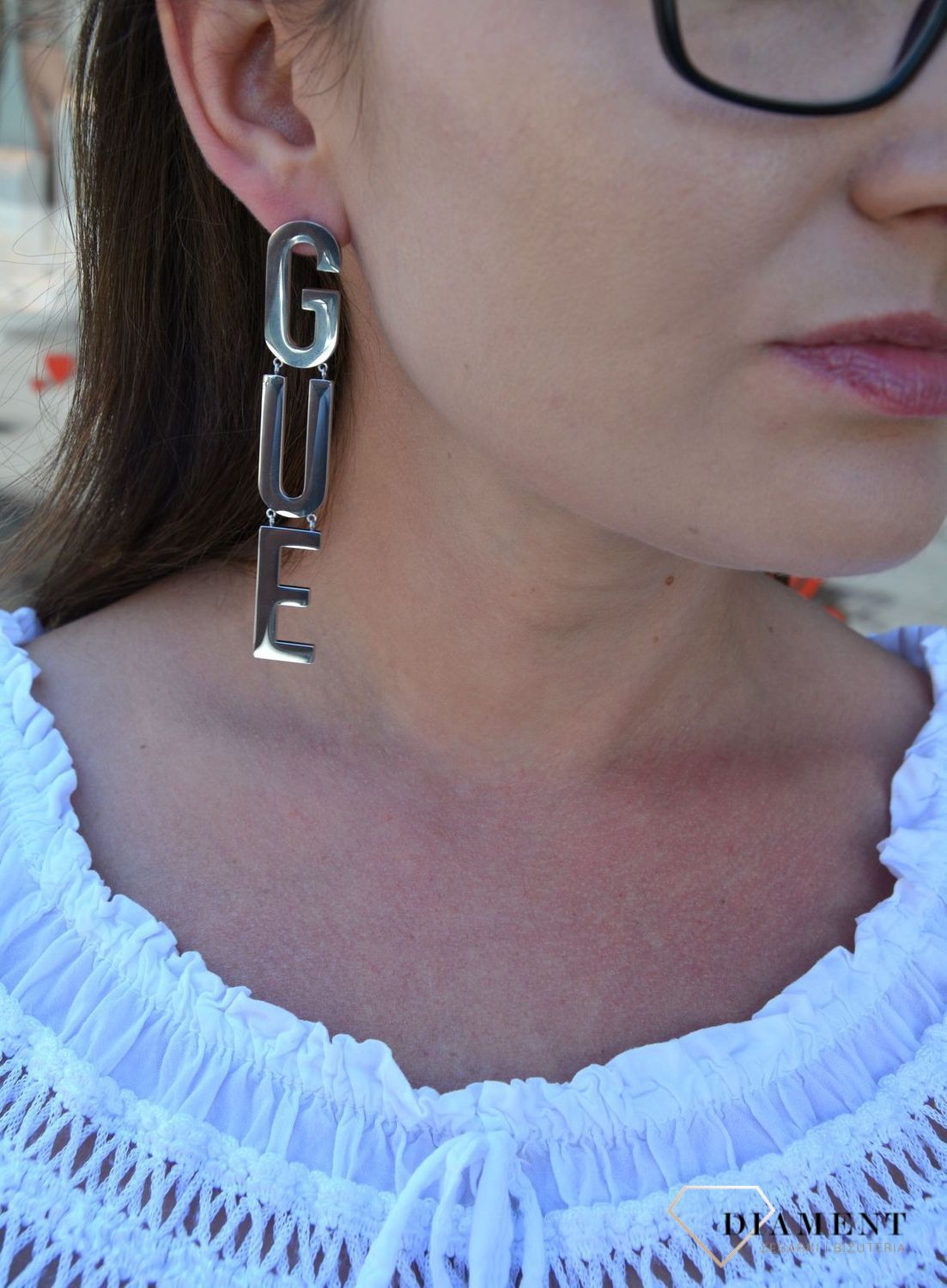 Kolczyki GUESS stalowe duży napis Guess UBE20002. Stalowe kolczyki duży napis Guess. Wiszące kolczyki z wygodnym zapięciem na sztyft. Kolczyki zostały wykonane w modny sposób. Idealnie komponuje się z ponadczasowym b.webp