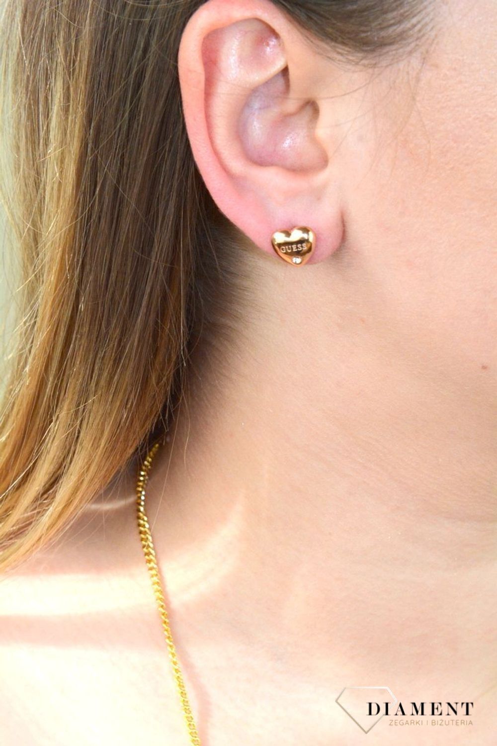 Kolczyki serca GUESS różowe złoto z cyrkonią UBE70106. Stalowe kolczyki w kształcie serca ozdobione napisem Guess i błyszczącą cyrkonią. Kolczyki w kolorze różowego złota, wypukłe..jpg