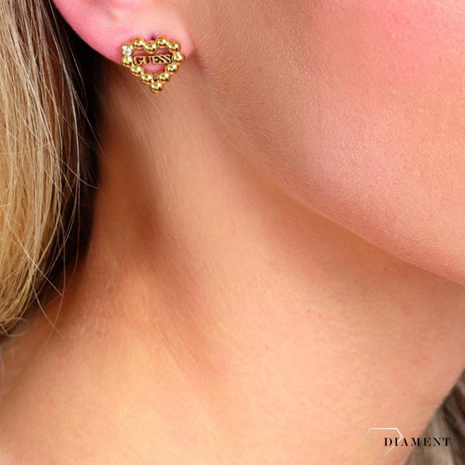 zyki GUESS stalowe pozłacane serce w nowoczesnej formie UBE70174. Stalowe kolczyki z motywem serca ozdobione na.jpg