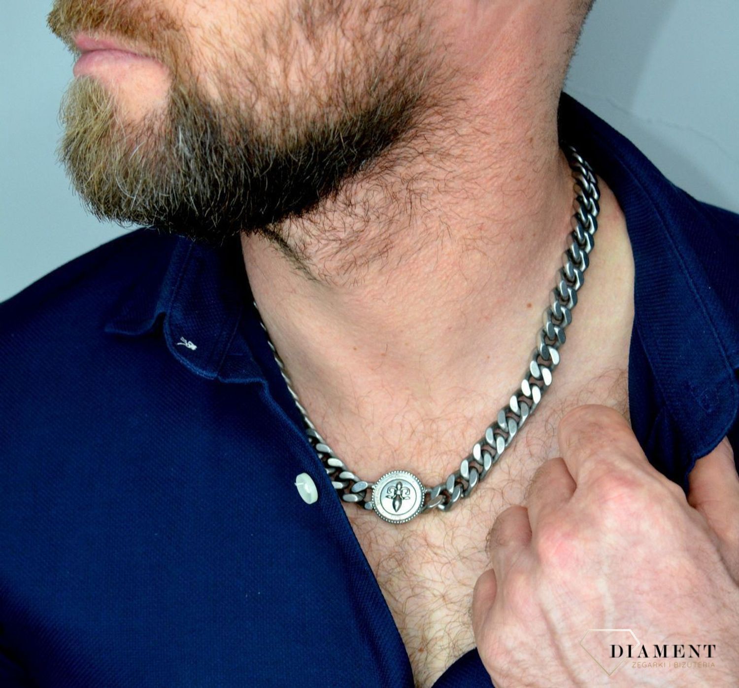 Naszyjnik męski GUESS w kolorze srebra z monetą  UMN70006.  Naszyjnik w formie srebrnej pancerki z logiem GUESS. Zawieszka w kształcie monety z motywem lilii i gra.jpg