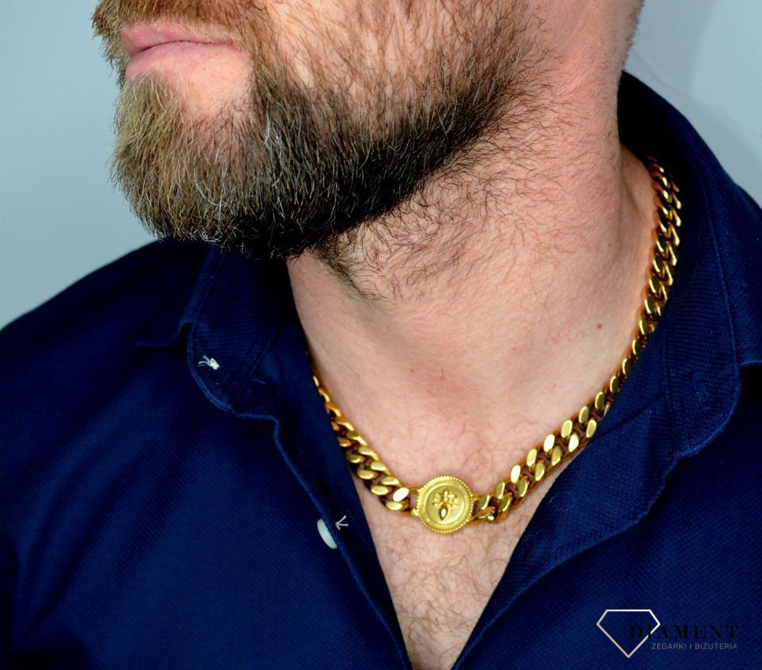 Naszyjnik męski GUESS z monetą i logo Guess UMN70007.  Naszyjnik w formie złotej pancerki z logiem GUESS. Zawieszka w kształcie monety z motywem lilii i grawerowan.jpg