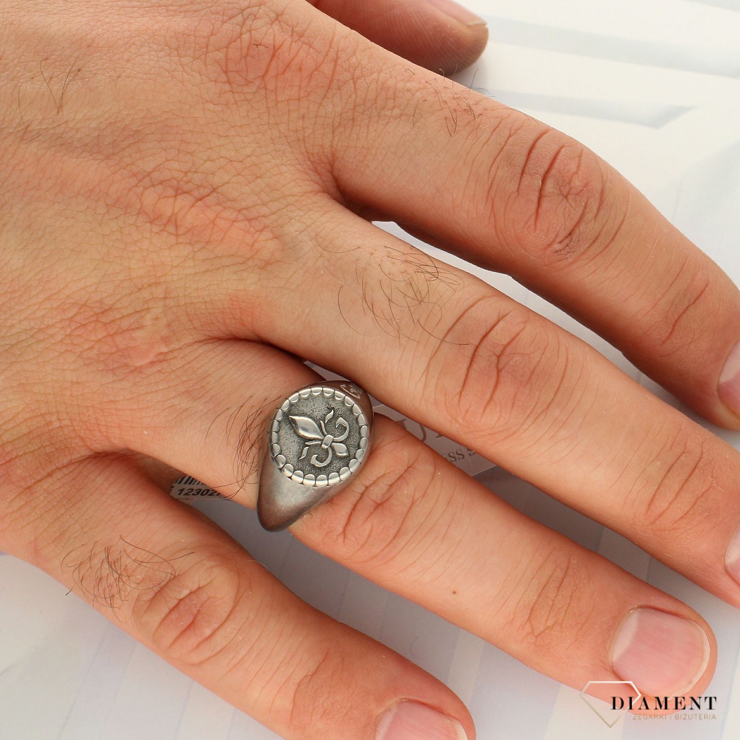 Sygnet męski GUESS w kolorze srebra UMR70002. Sygnet męski GUESS w kolorze srebra z napisem marki GUESS.  Stalowy pierścionek  pozłacany w formie sygnetu wydają si.jpg