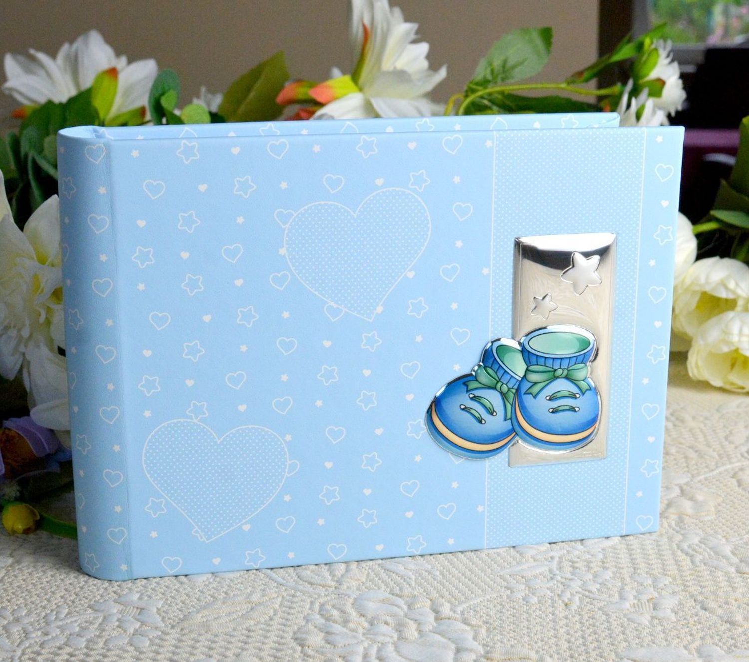 Album na chrzest, roczek dla dziecka. Album na zdjęcia produkowany ze skóry organicznej. Na okładce znajduje się posrebrzany obrazek z motywem niebieskich bucików..jpg