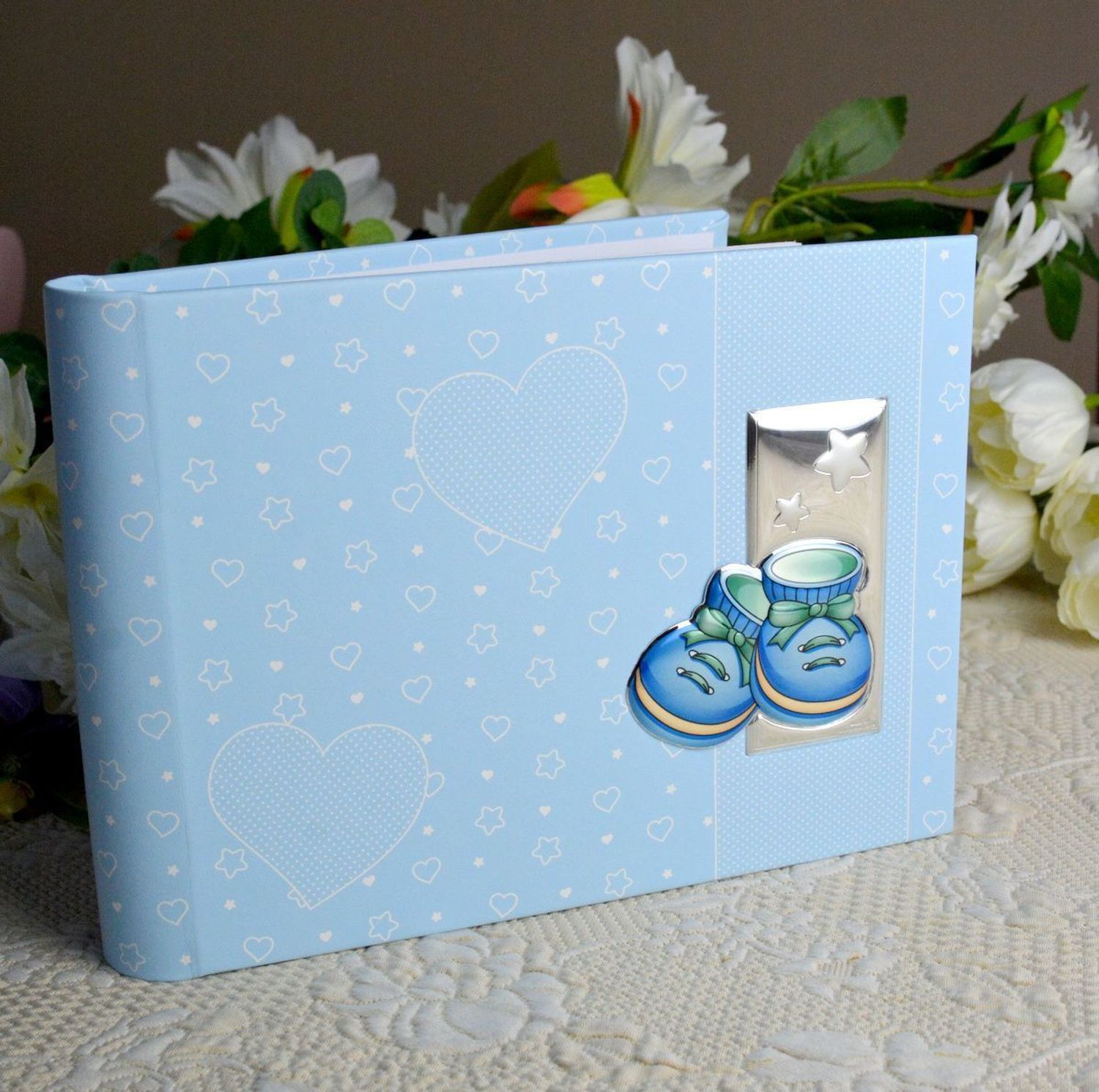 Album na chrzest, roczek dla dziecka. Album na zdjęcia produkowany ze skóry organicznej. Na okładce znajduje się posrebrzany obrazek z motywem niebieskich bucików..jpg