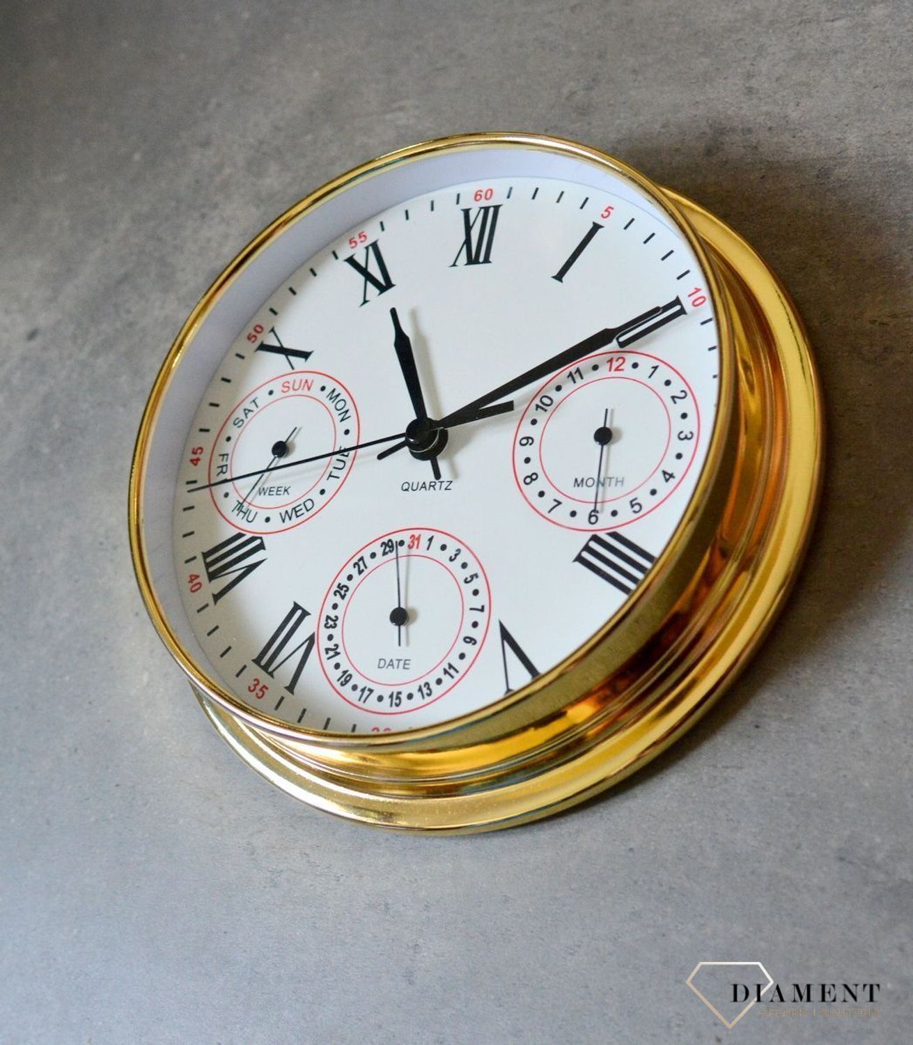 Zegar wyposażony jest w kwarcowy mechanizm, zasilany za pomocą baterii. MULTIDATA Zegar złoty mały z kalendarzem rozmieszczonym na trzech małych tarczach.  (7).JPG