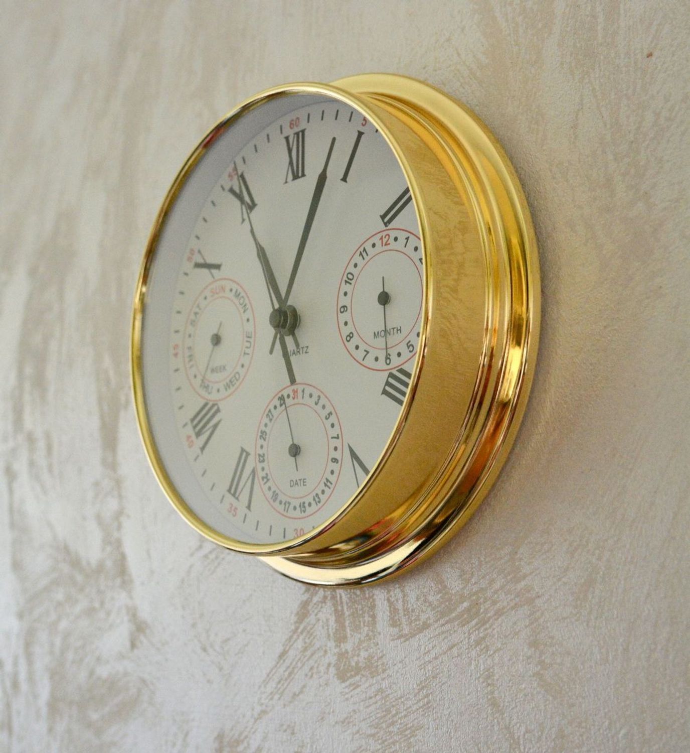 Zegar wyposażony jest w kwarcowy mechanizm, zasilany za pomocą baterii. MULTIDATA Zegar złoty mały z kalendarzem rozmieszczonym na trzech małych tarczach.  (7).JPG