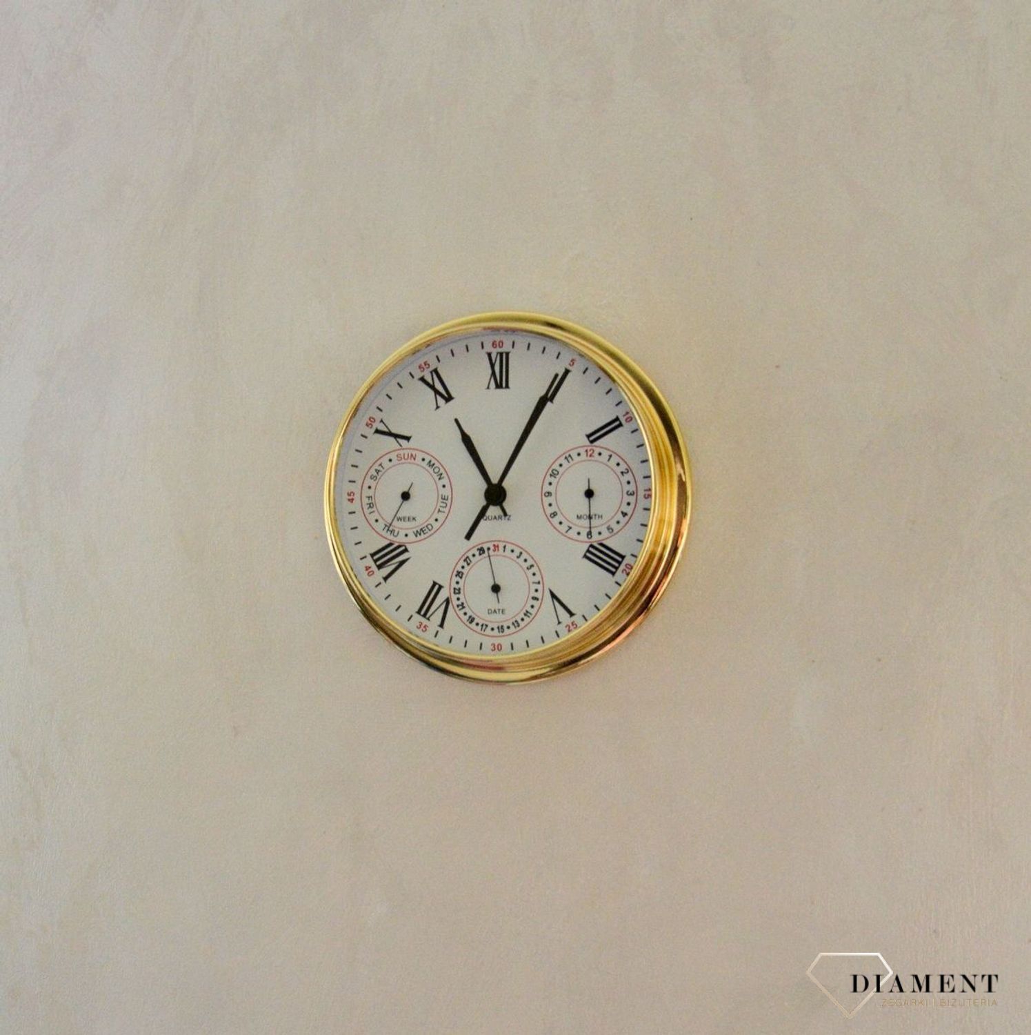 Zegar wyposażony jest w kwarcowy mechanizm, zasilany za pomocą baterii. MULTIDATA Zegar złoty mały z kalendarzem rozmieszczonym na trzech małych tarczach.  (7).JPG