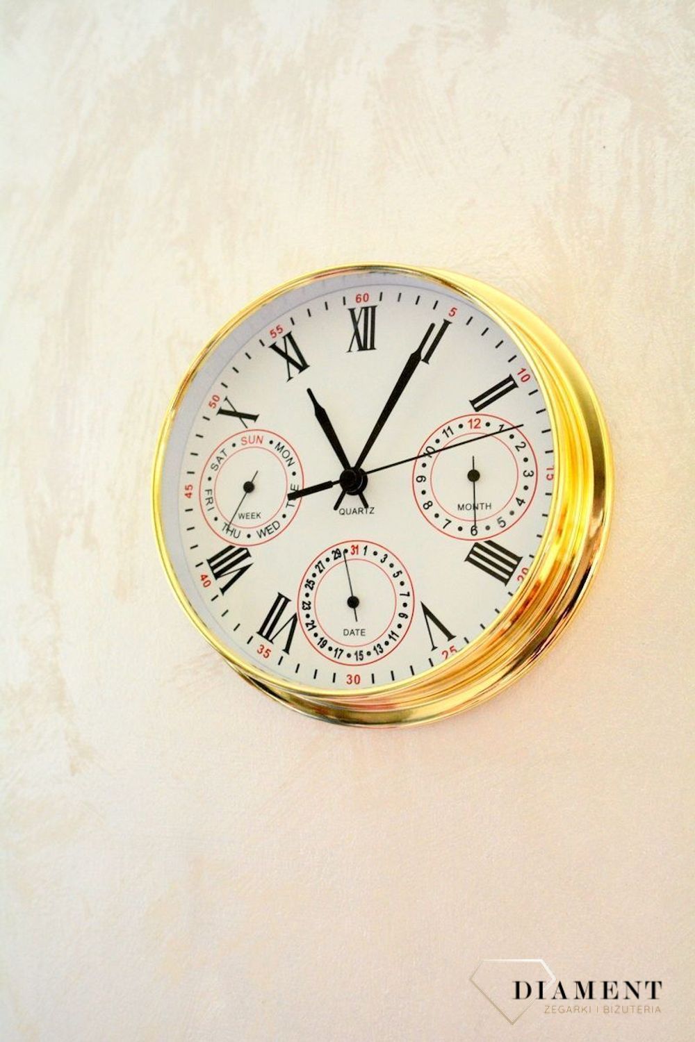 Zegar wyposażony jest w kwarcowy mechanizm, zasilany za pomocą baterii. MULTIDATA Zegar złoty mały z kalendarzem rozmieszczonym na trzech małych tarczach.  (7).JPG