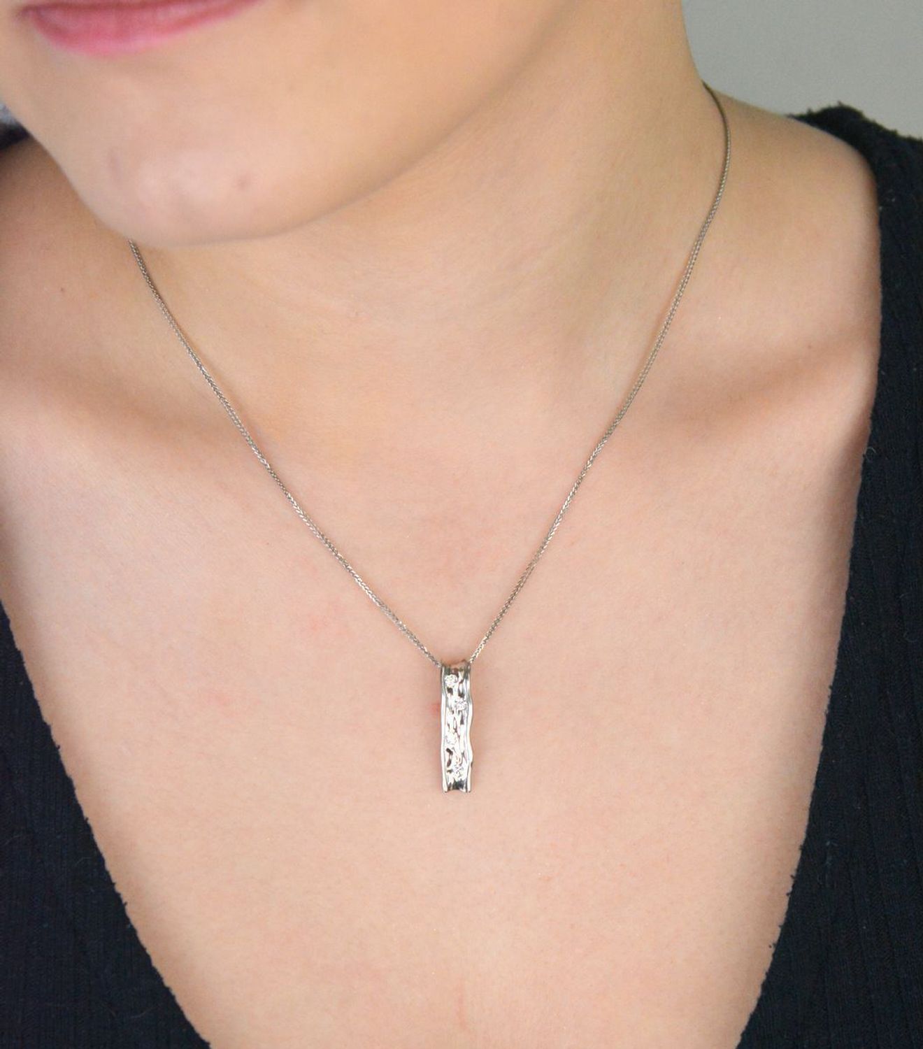 Nowoczesna srebrna zawieszka ZVI113021 o podłużnym, nieregularnym kształcie. Zdobiona cyrkonią, wykonana ze srebra próby 925. Długość 2,5 cm, szerokość 6 mm, waga 1,50 g – idealna dla kobiet 1.jpg