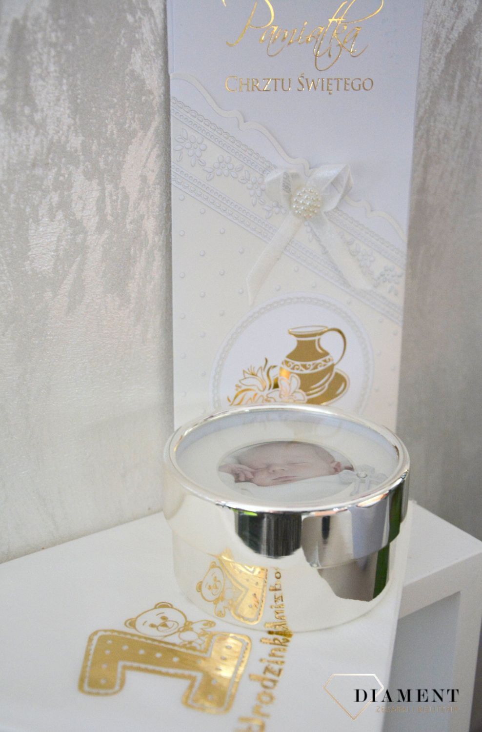 Śliczne puzderko z ramką na zdjęcie zdobione krzyżykiem, który przypominał będzie o istotnej okoliczności dla każdego chrześcijanina jakim jest chrzest..png